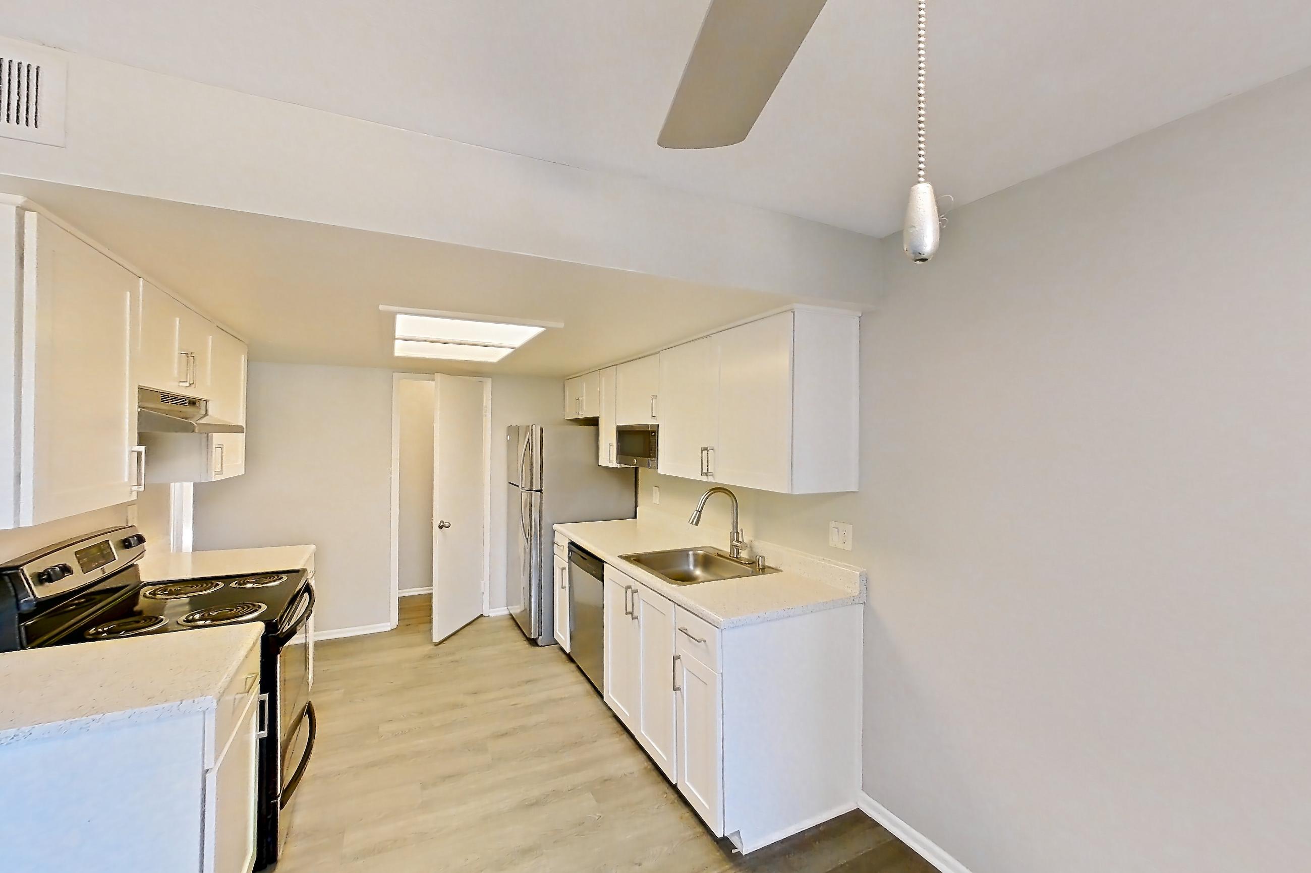 Dining area with dishwasher, electric range, light countertops, light wood-finish flooring, oven/range, refrigerator, stainless steel appliances, and white appliances, Apartment 07 at Avana Rancho Cucamonga