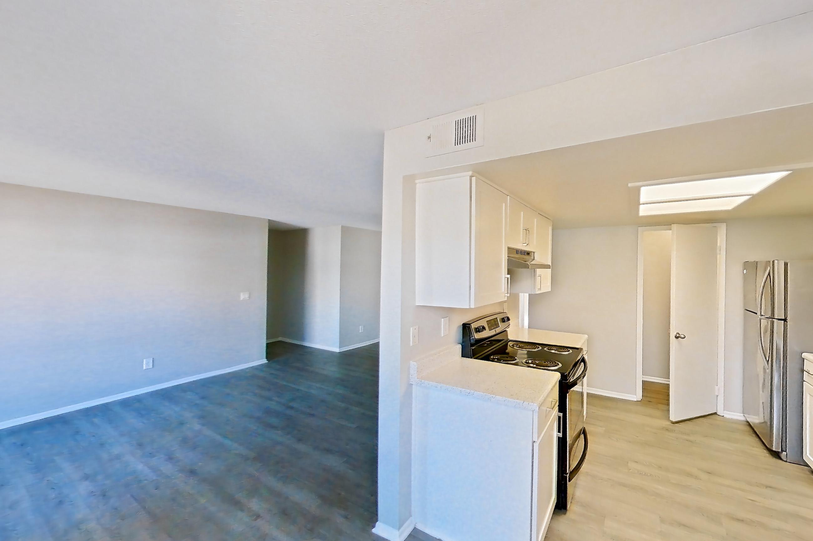 Dining area with dishwasher, electric range, light countertops, light wood-finish flooring, oven/range, refrigerator, stainless steel appliances, and white appliances, Apartment 07 at Avana Rancho Cucamonga