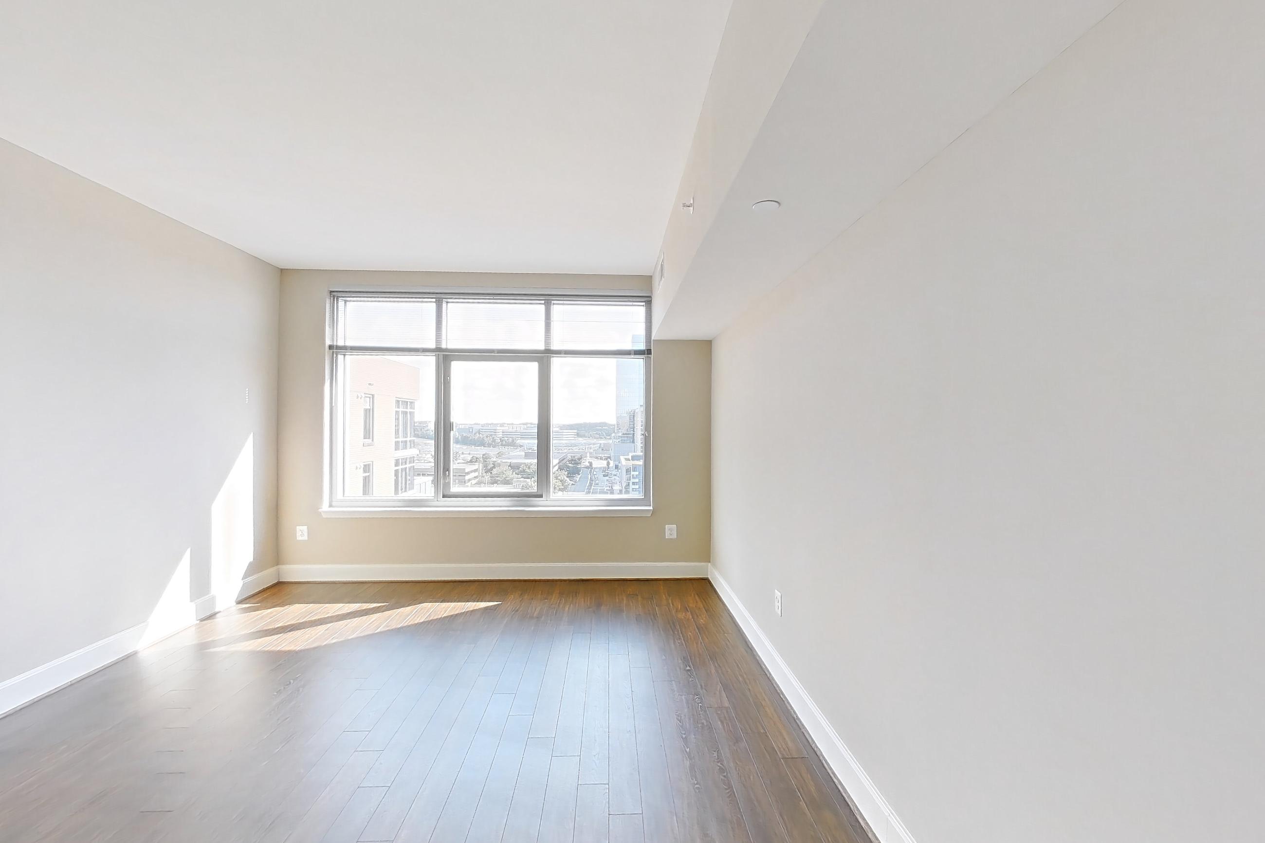Living room 1 with dark wood-finish flooring and wood-finish flooring, Apartment 1315 at The Avant at Reston Town Center