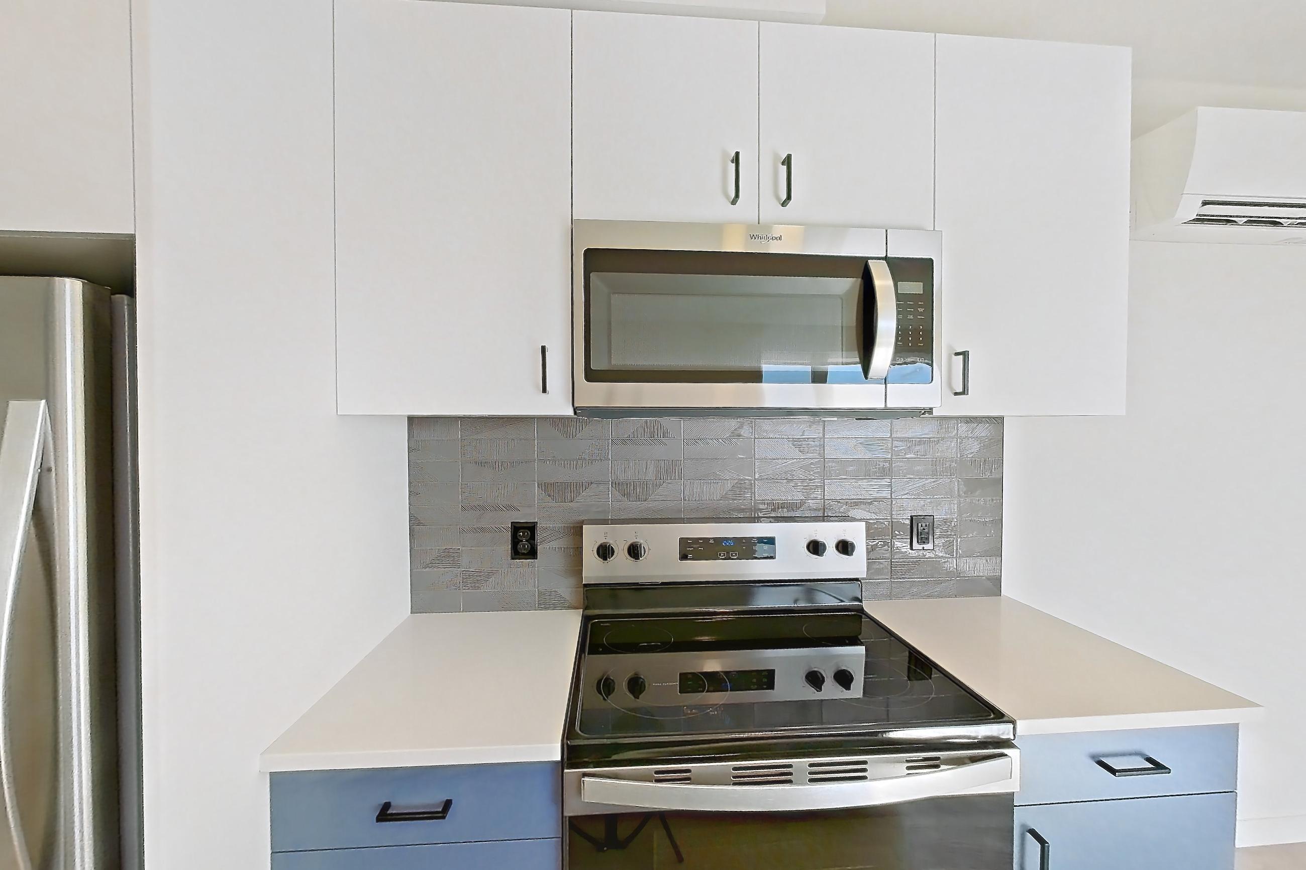 Kitchen with dishwasher, electric range, light countertops, light wood-finish flooring, oven/range, refrigerator, and stainless steel appliances, Apartment 743 at Cascara