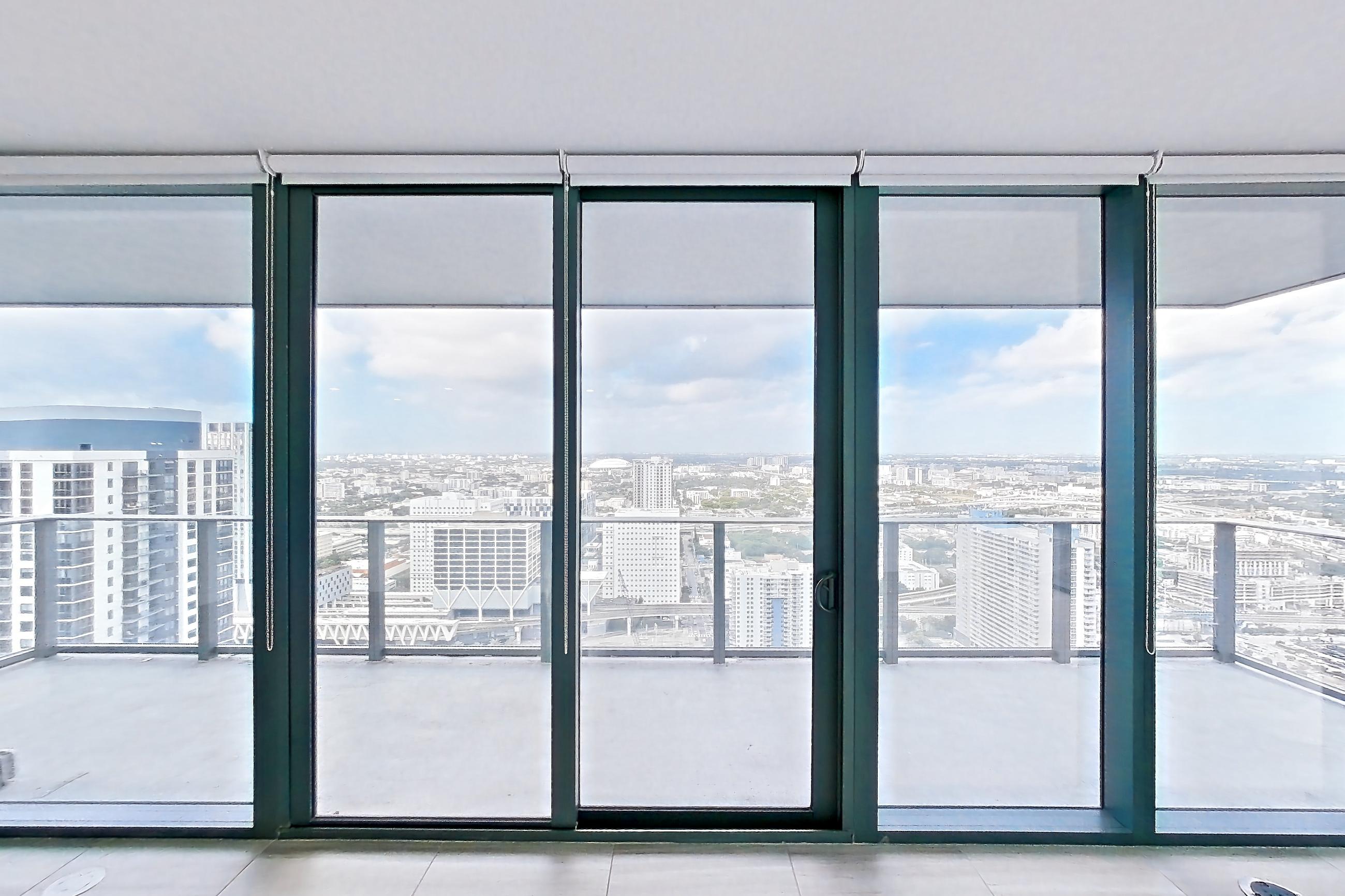 Living room with city view and light tile flooring, Apartment 4601 at Miami World Tower