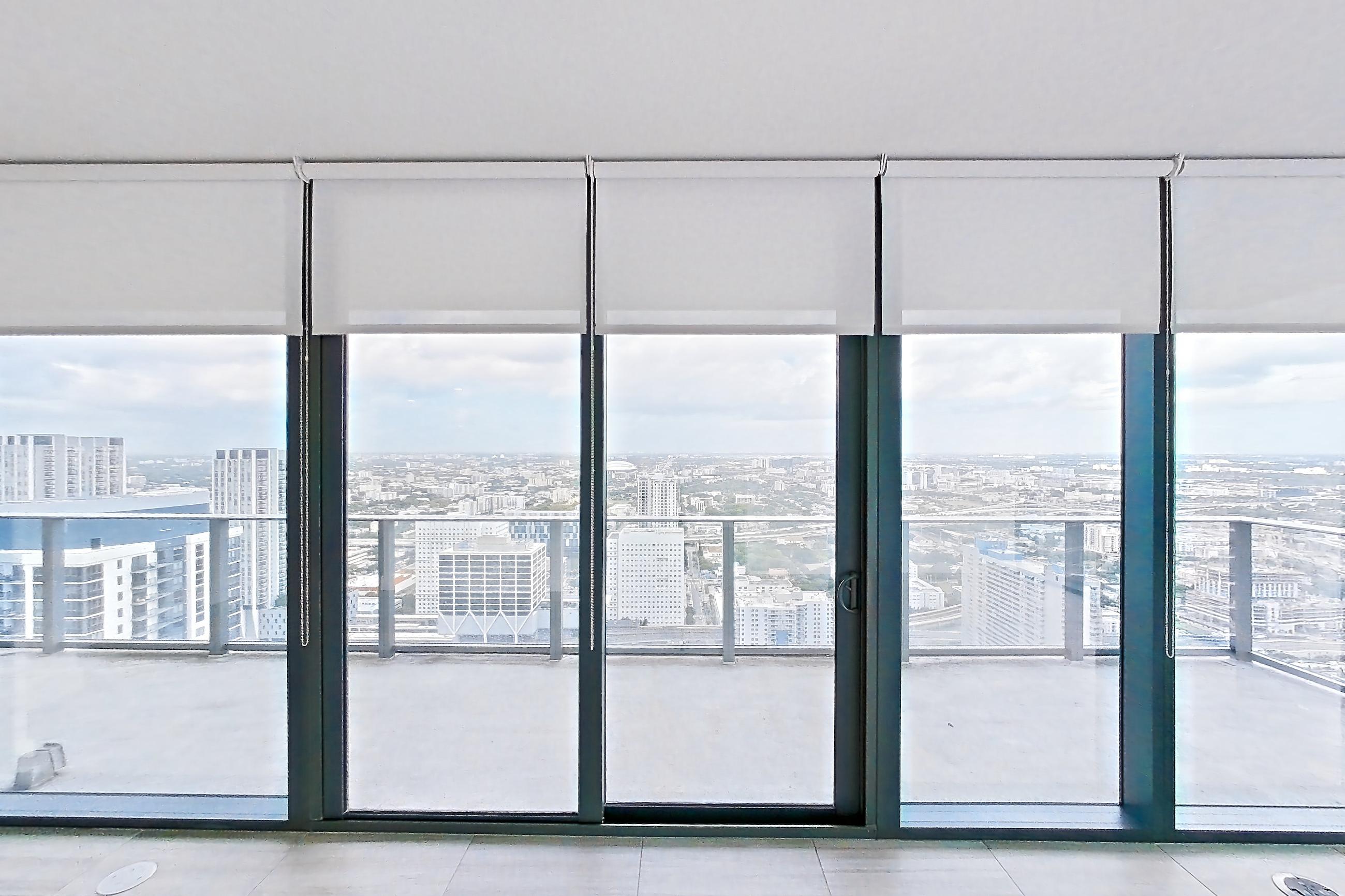 Living room with city view and light tile flooring, Apartment 5201 at Miami World Tower