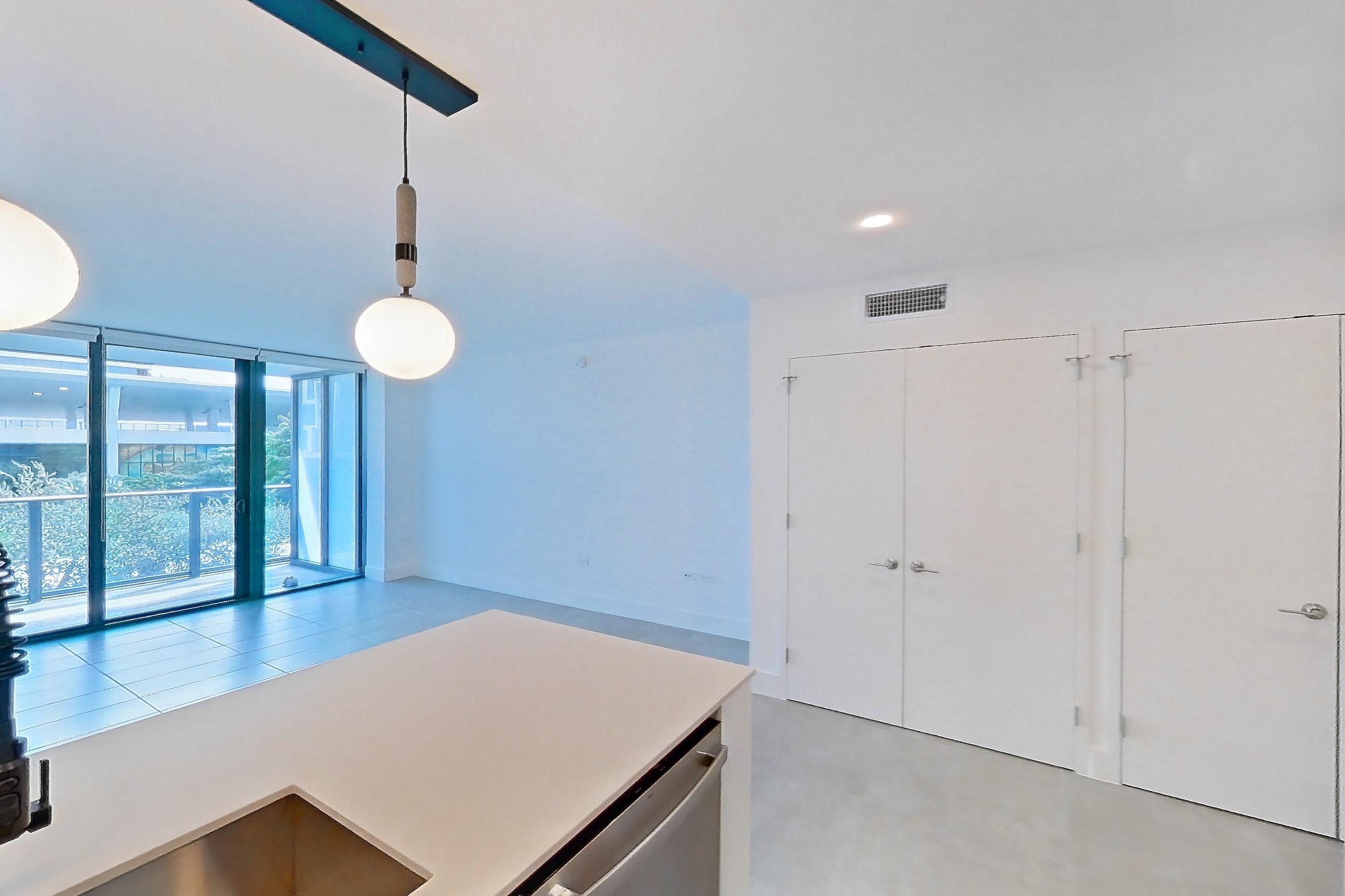 Kitchen with dishwasher, light countertops, light tile flooring, oven/range, refrigerator, and stainless steel appliances, Apartment 0508 at Miami World Tower
