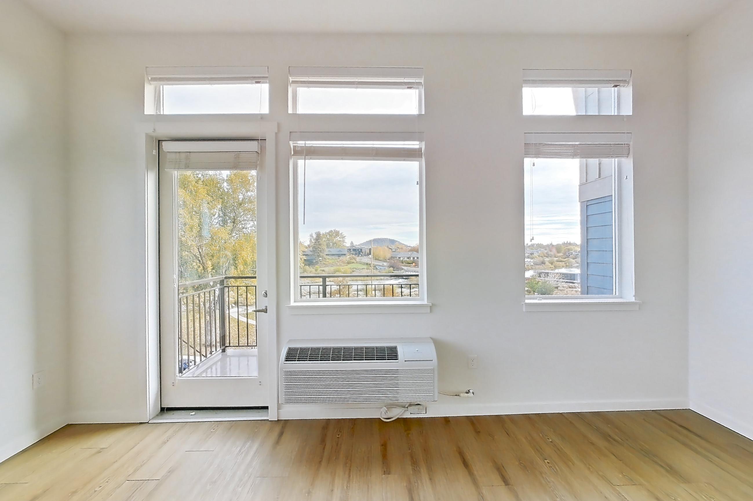 Living room with air conditioning and light wood-finish flooring, Apartment 335 at The Eddy Apartments