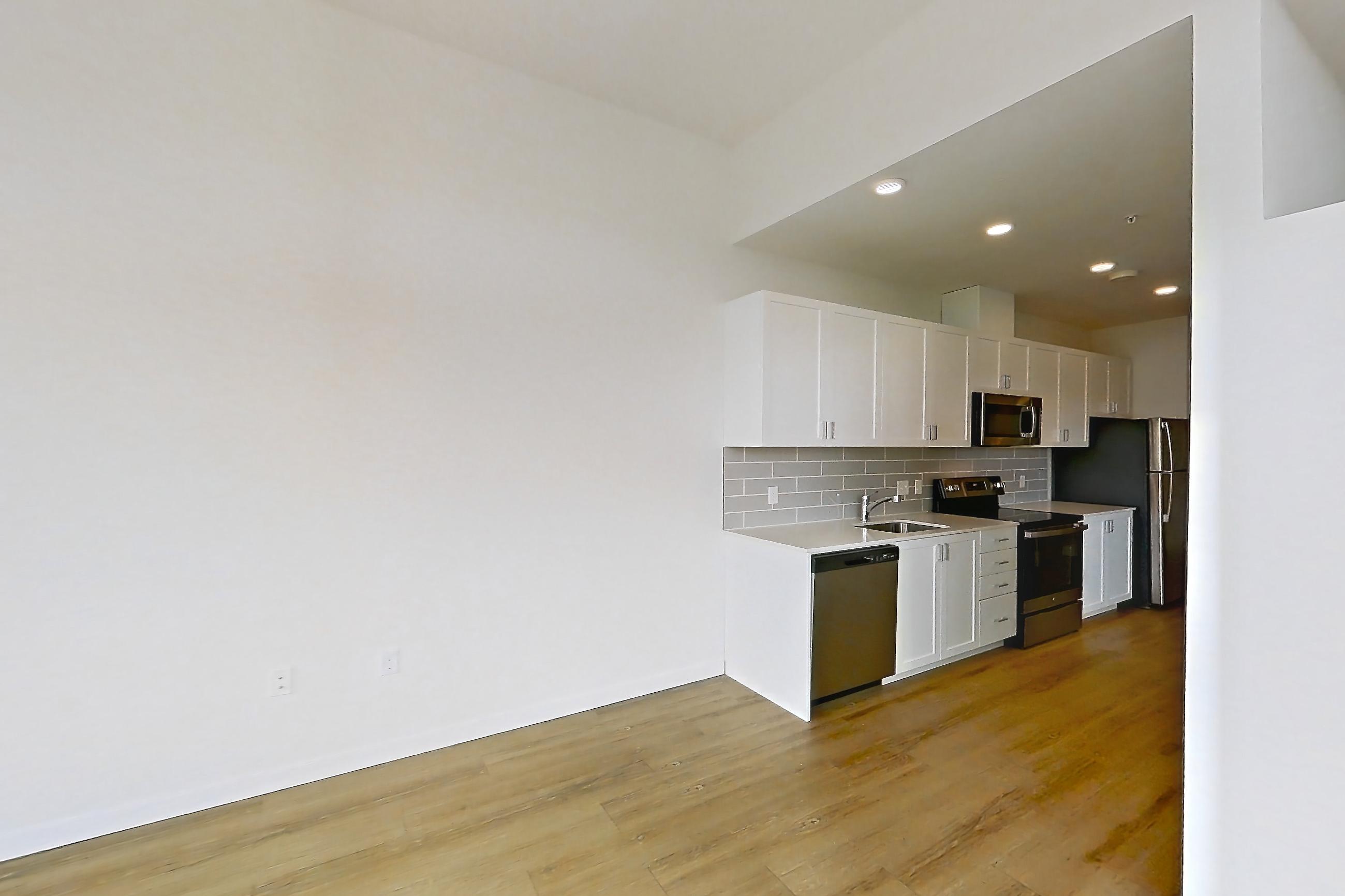 Living room with air conditioning and light wood-finish flooring, Apartment 335 at The Eddy Apartments