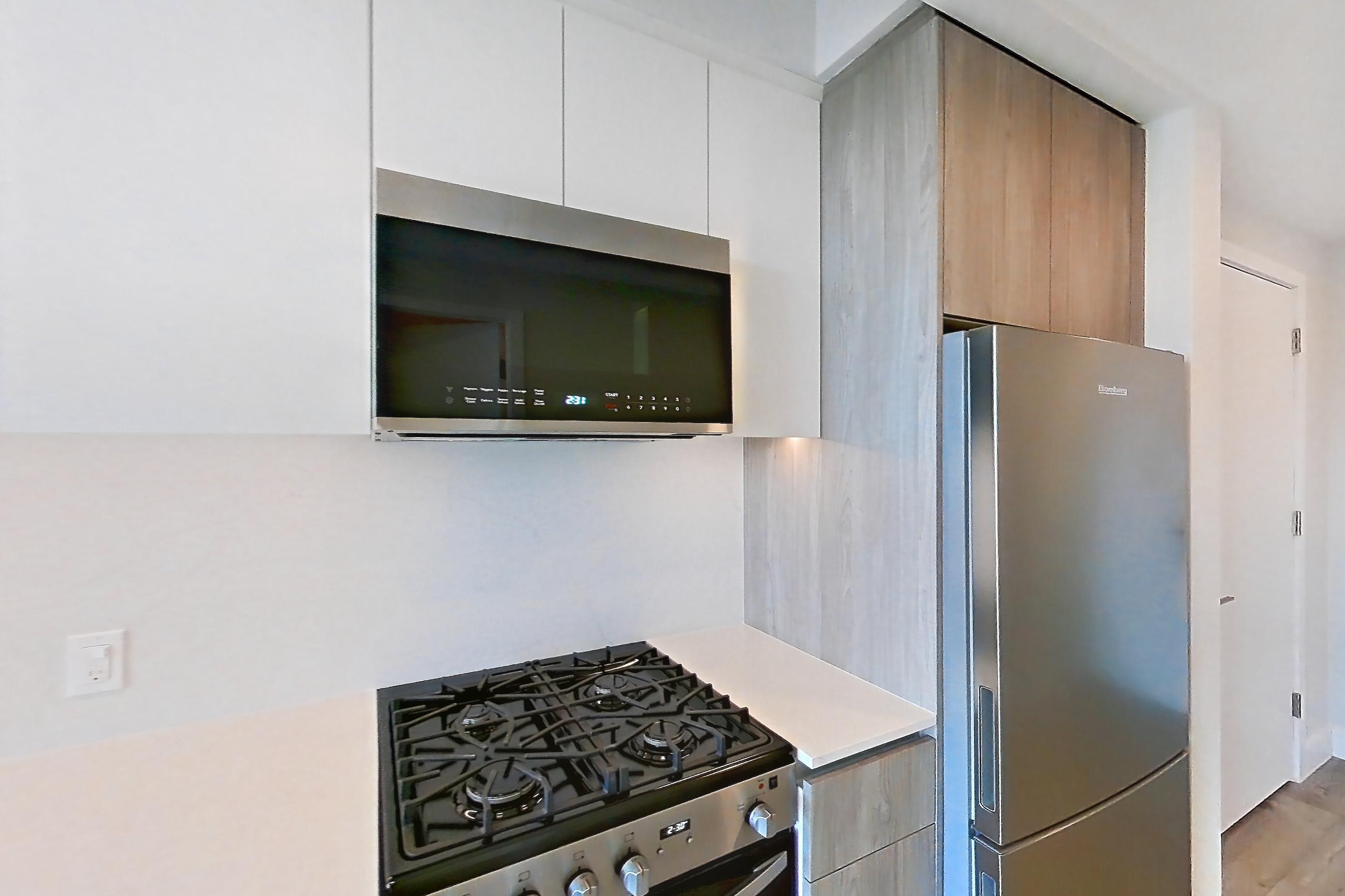 Kitchen with gas range, light wood-finish flooring, oven/range, and stainless steel appliances, Apartment 0535 at Loden