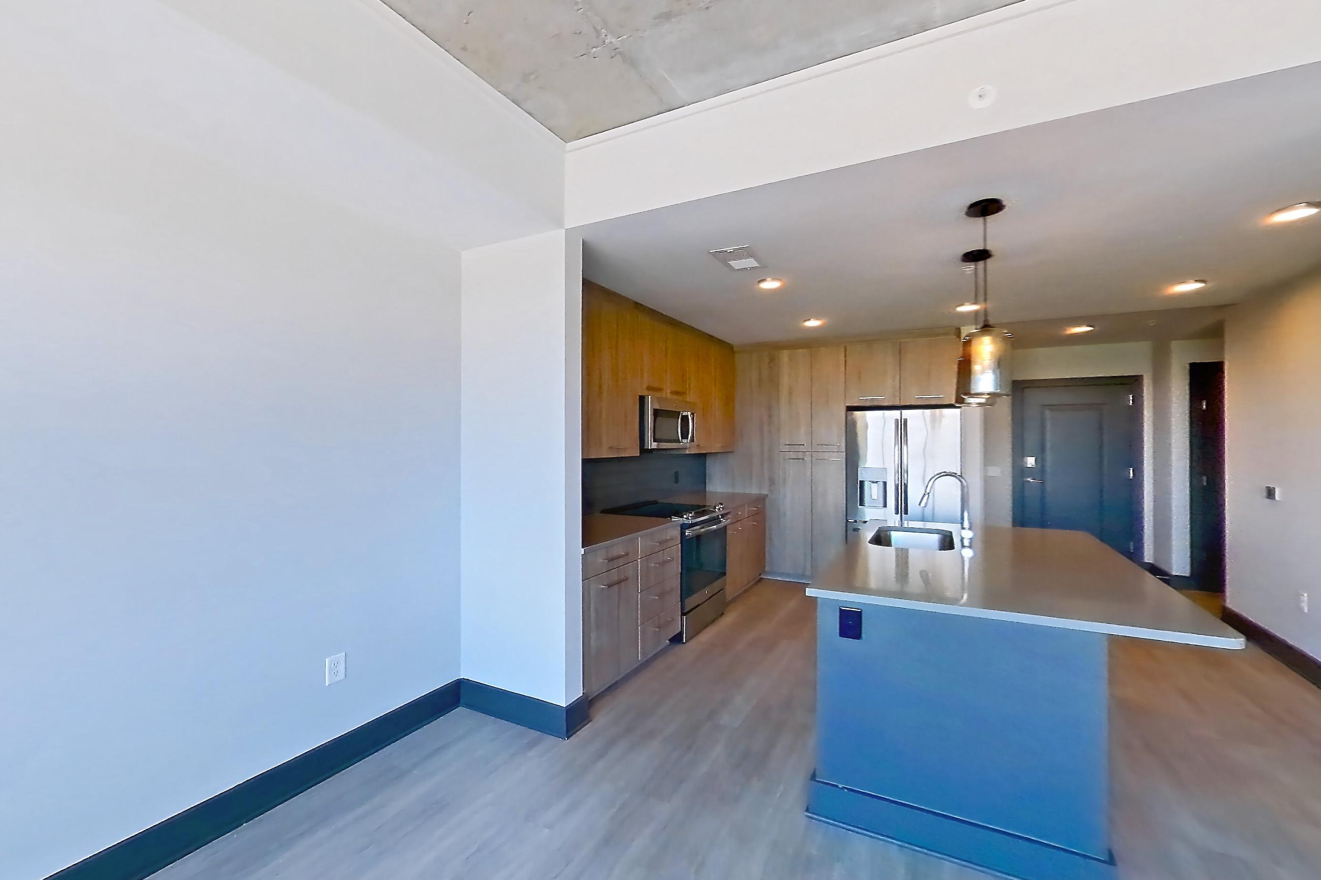 Living room with electric range, kitchen island, light countertops, oven/range, refrigerator, stainless steel appliances, and water & ice dispenser, Apartment 1116 at Cortland Glenwood South