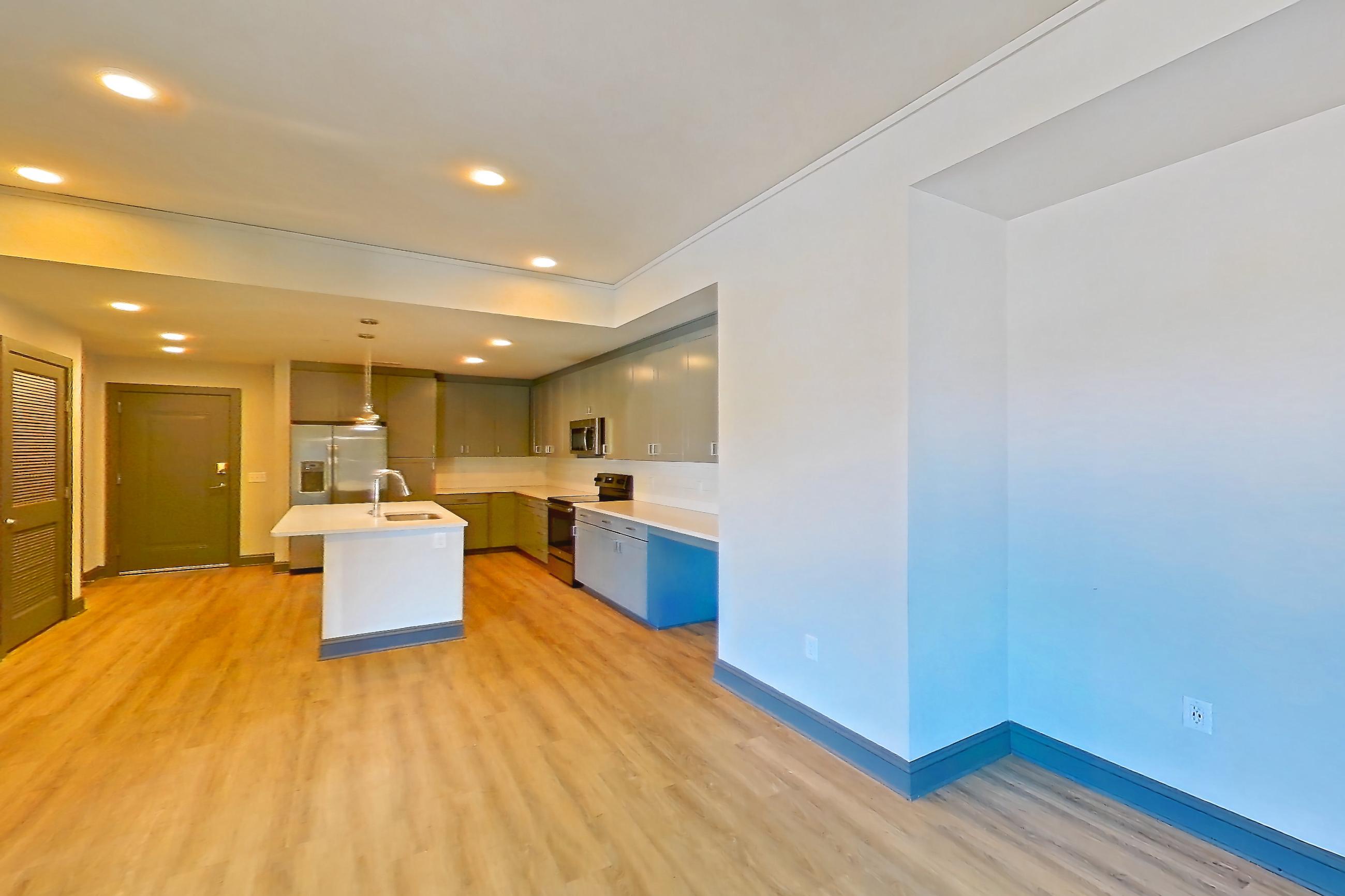 Living room with electric range, kitchen island, light countertops, light wood-finish flooring, oven/range, refrigerator, and stainless steel appliances, Apartment 426 at Cortland Glenwood South