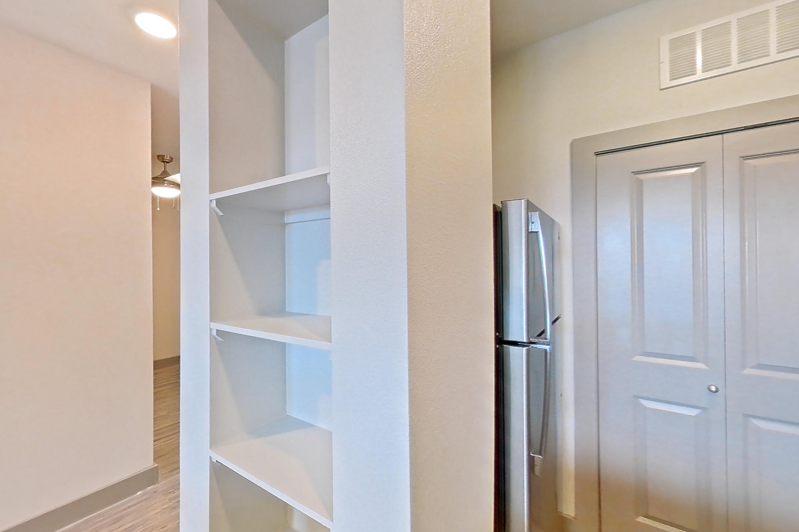 Kitchen with dishwasher, electric range, light countertops, light stone countertops, light wood-finish flooring, microwave, oven/range, refrigerator, and stainless steel appliances, Apartment 05103 at Embree Hill