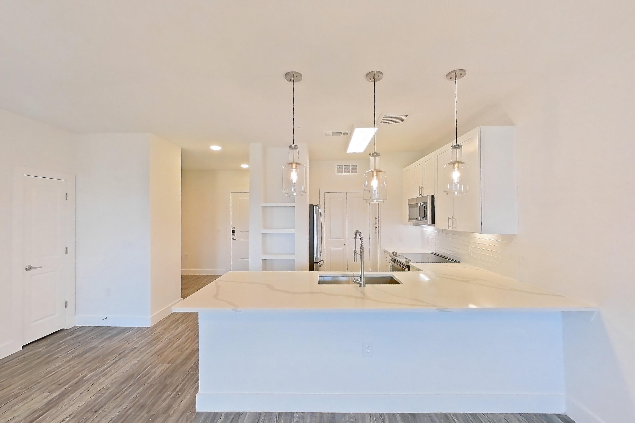 Living room with dark wood-finish flooring, electric range, light stone countertops, oven/range, refrigerator, and stainless steel appliances, Apartment 08306 at Embree Hill