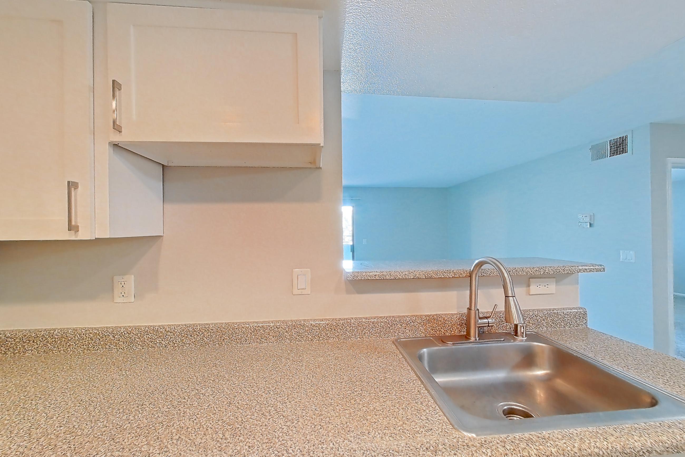 Kitchen with dishwasher, electric range, light countertops, light stone countertops, light wood-finish flooring, oven/range, and stainless steel appliances, Apartment 13 at Avana Rancho Cucamonga