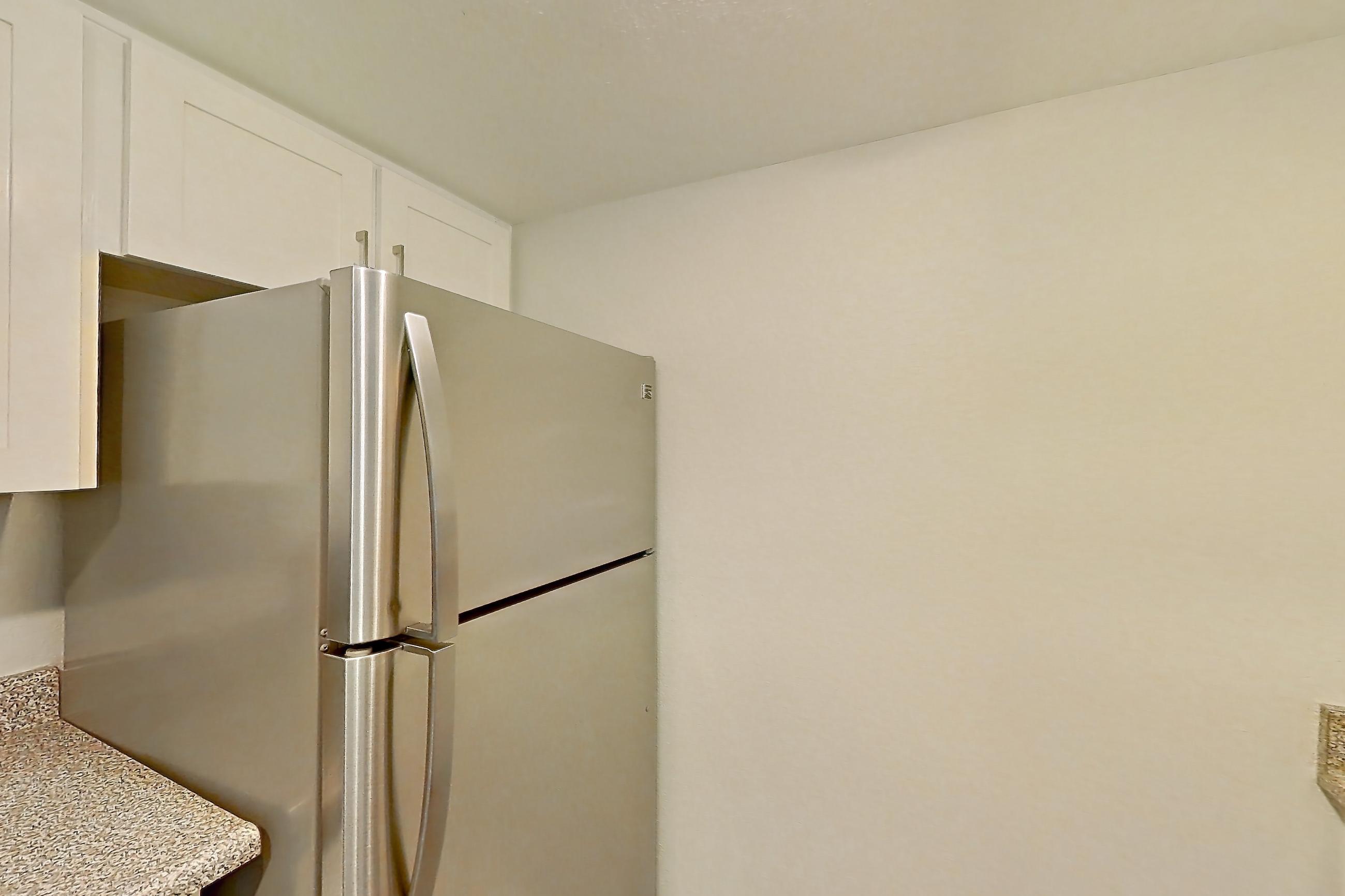 Kitchen with dishwasher, electric range, light countertops, light stone countertops, microwave, oven/range, refrigerator, stainless steel appliances, and white appliances, Apartment 08 at Avana Rancho Cucamonga