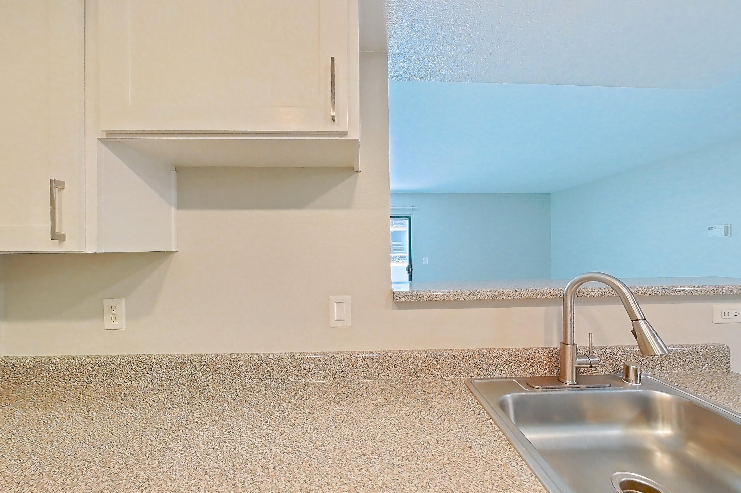 Kitchen with dishwasher, electric range, light countertops, light stone countertops, oven/range, and stainless steel appliances, Apartment 16 at Avana Rancho Cucamonga