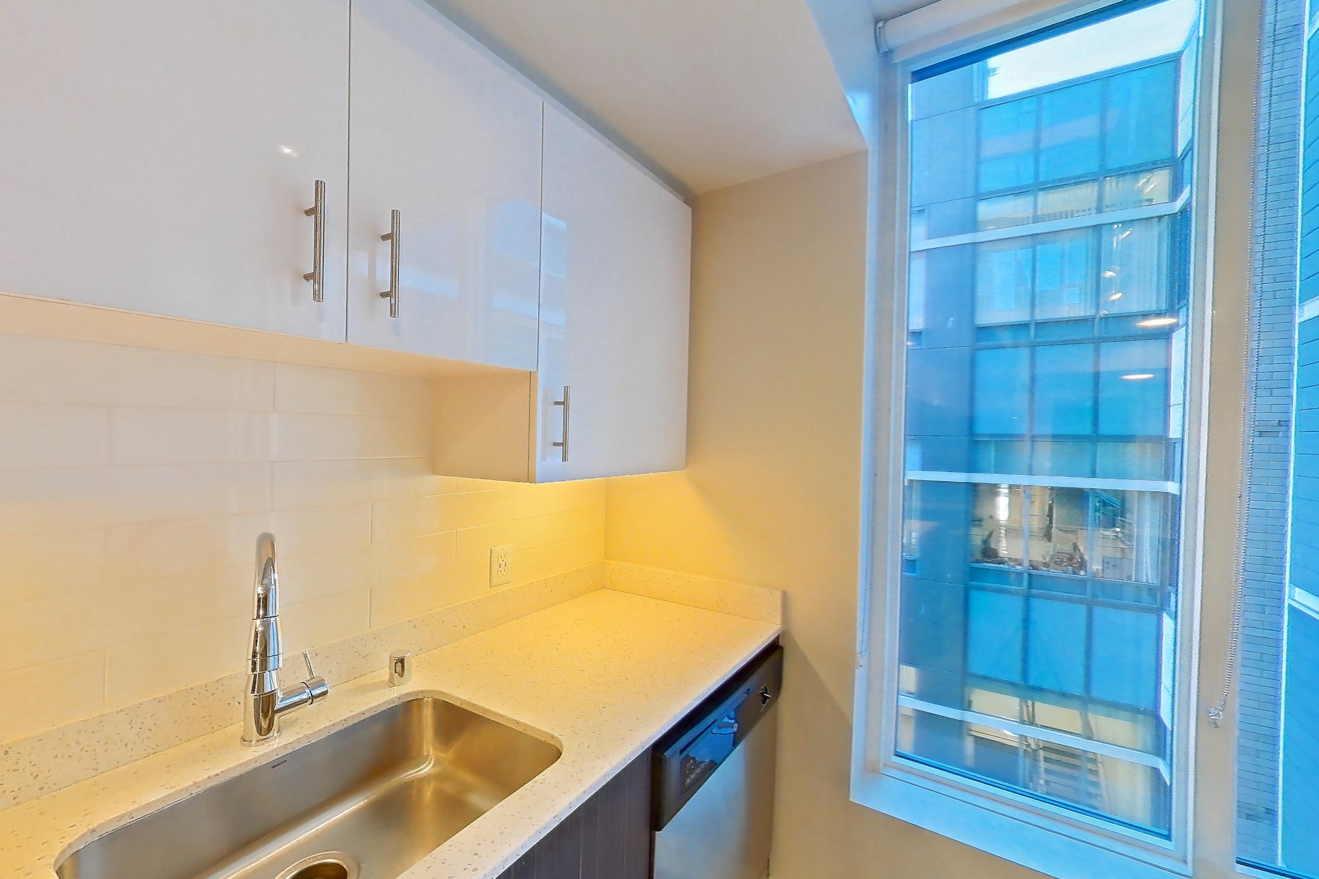 Kitchen with dishwasher, electric range, light countertops, light stone countertops, light wood-finish flooring, oven/range, refrigerator, and stainless steel appliances, Apartment 0-0805 at Cielo