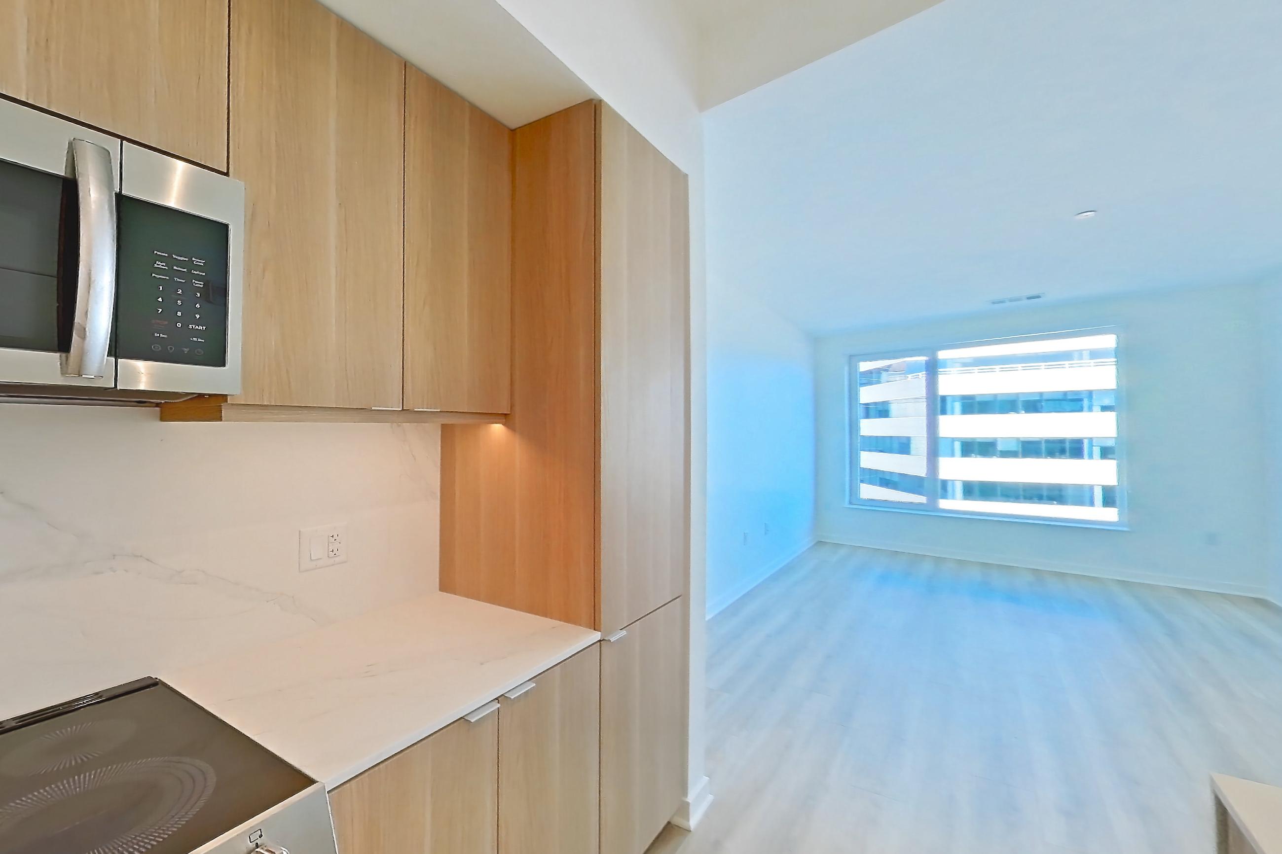 Kitchen with electric range, light stone countertops, light wood-finish flooring, oven/range, and stainless steel appliances, Apartment 625 at Residences at Mazza