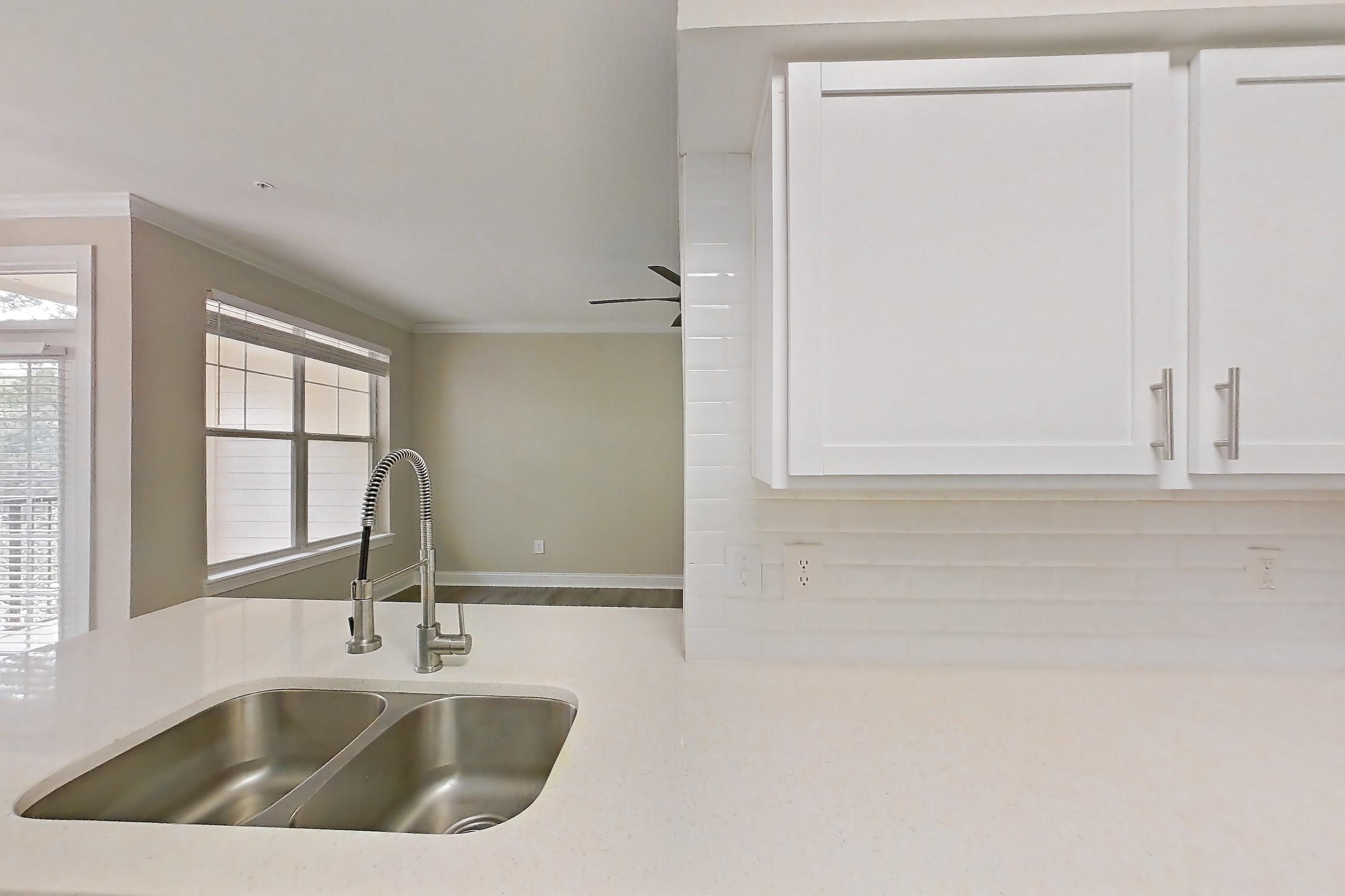 Kitchen with dishwasher, electric range, light countertops, light stone countertops, light wood-finish flooring, oven/range, refrigerator, and stainless steel appliances, Apartment 4314 at Marq Perimeter