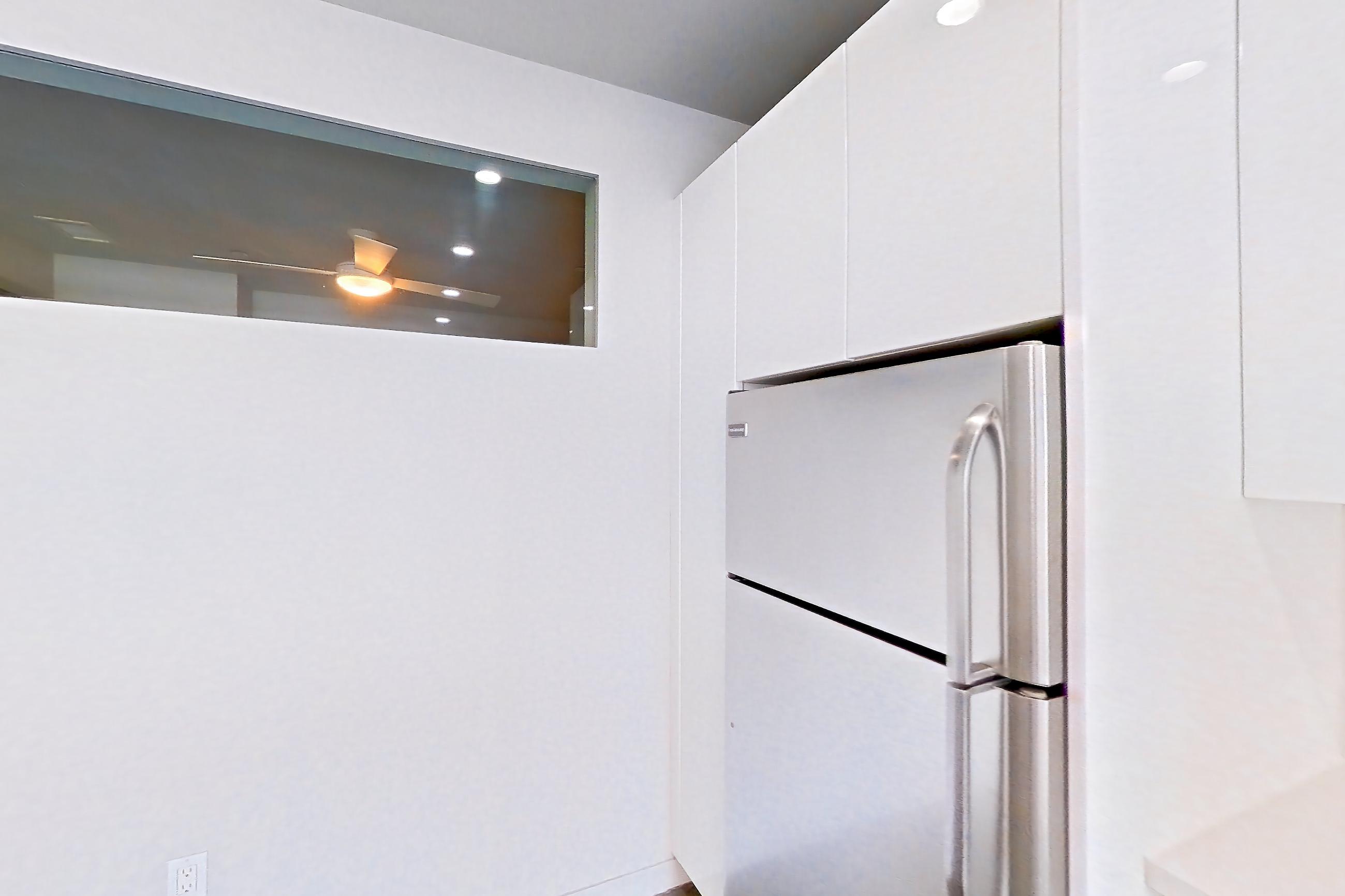 Kitchen with light countertops, oven/range, polished concrete flooring, refrigerator, stainless steel appliances, and white appliances, Apartment 0-2077 at Eighth and Grand