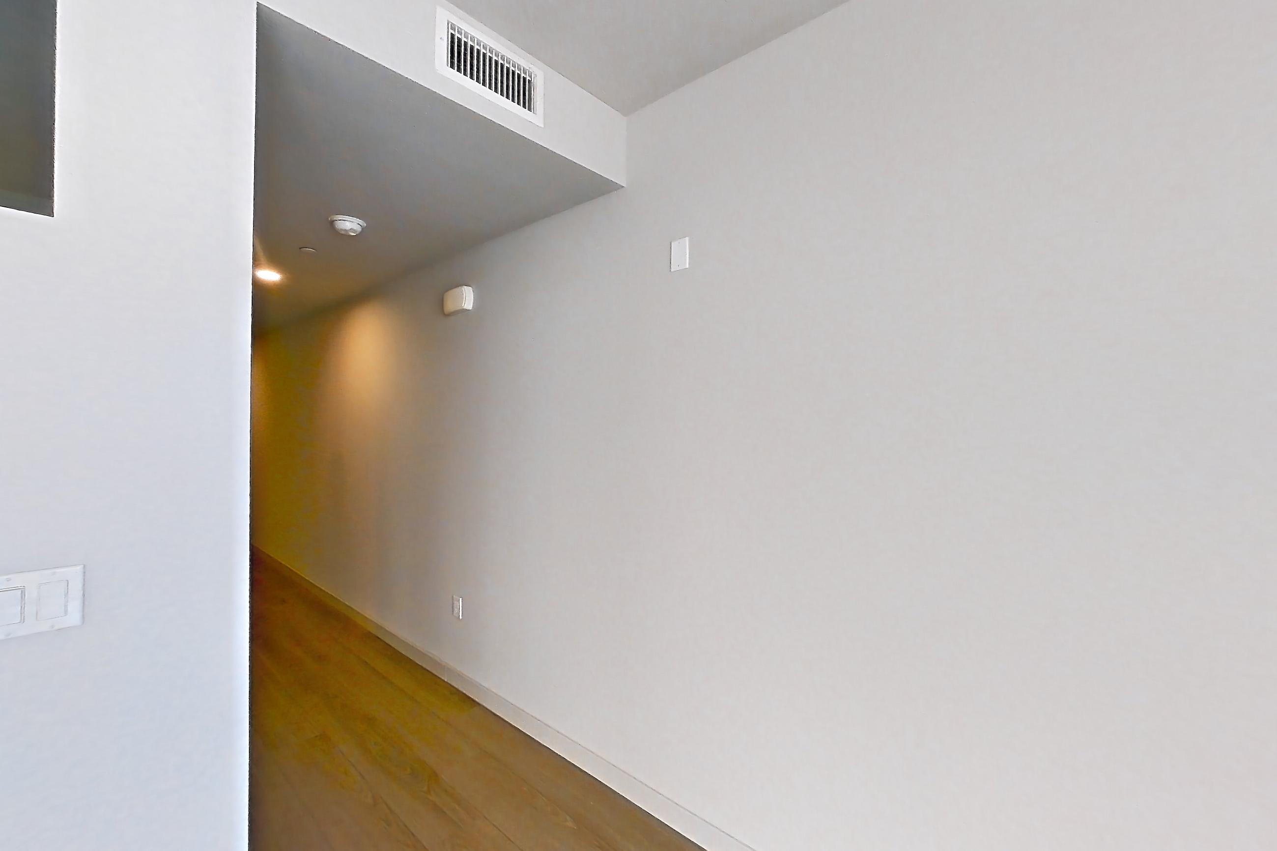 Living room with light countertops, light wood-finish flooring, refrigerator, and stainless steel appliances, Apartment 0-5006 at Eighth and Grand