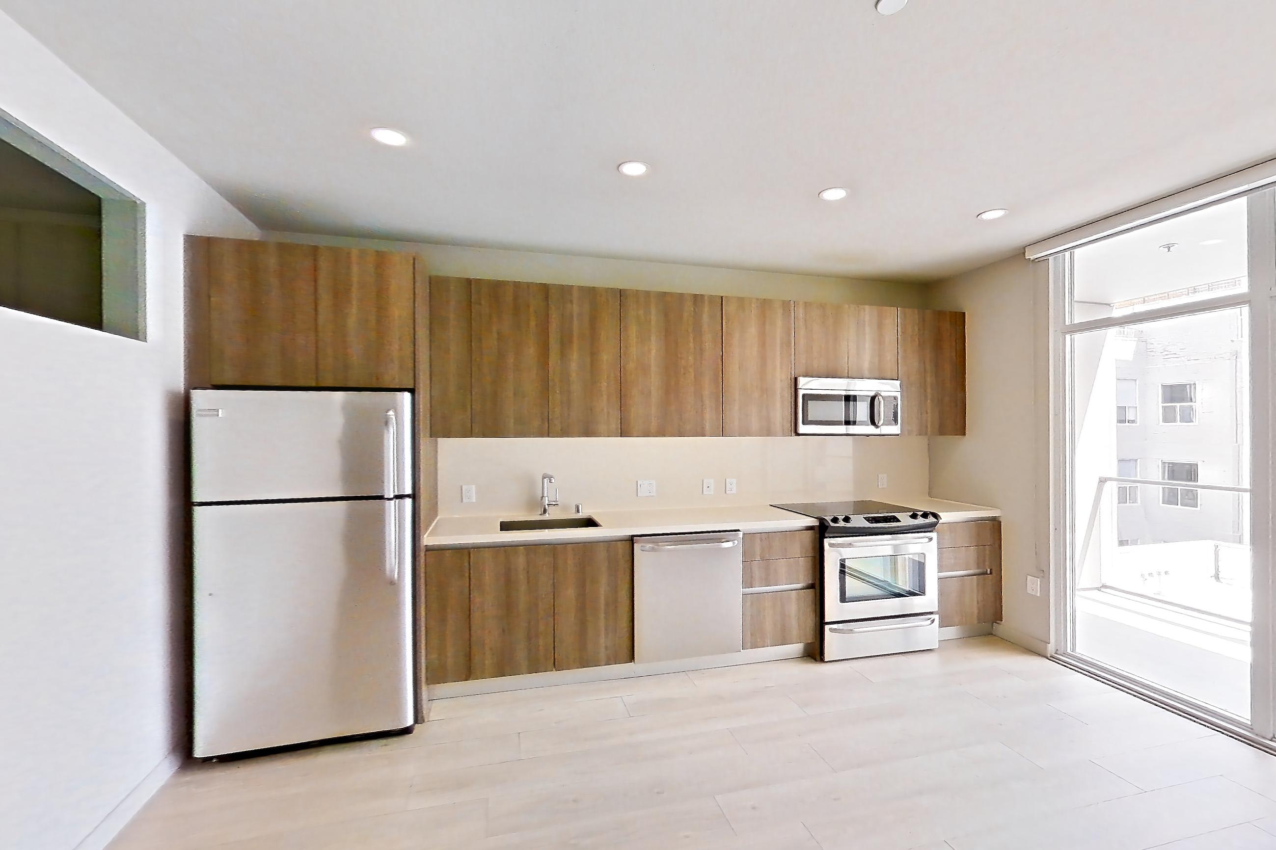 Living room with dishwasher, light countertops, light wood-finish flooring, refrigerator, and stainless steel appliances, Apartment 0-5046 at Eighth and Grand
