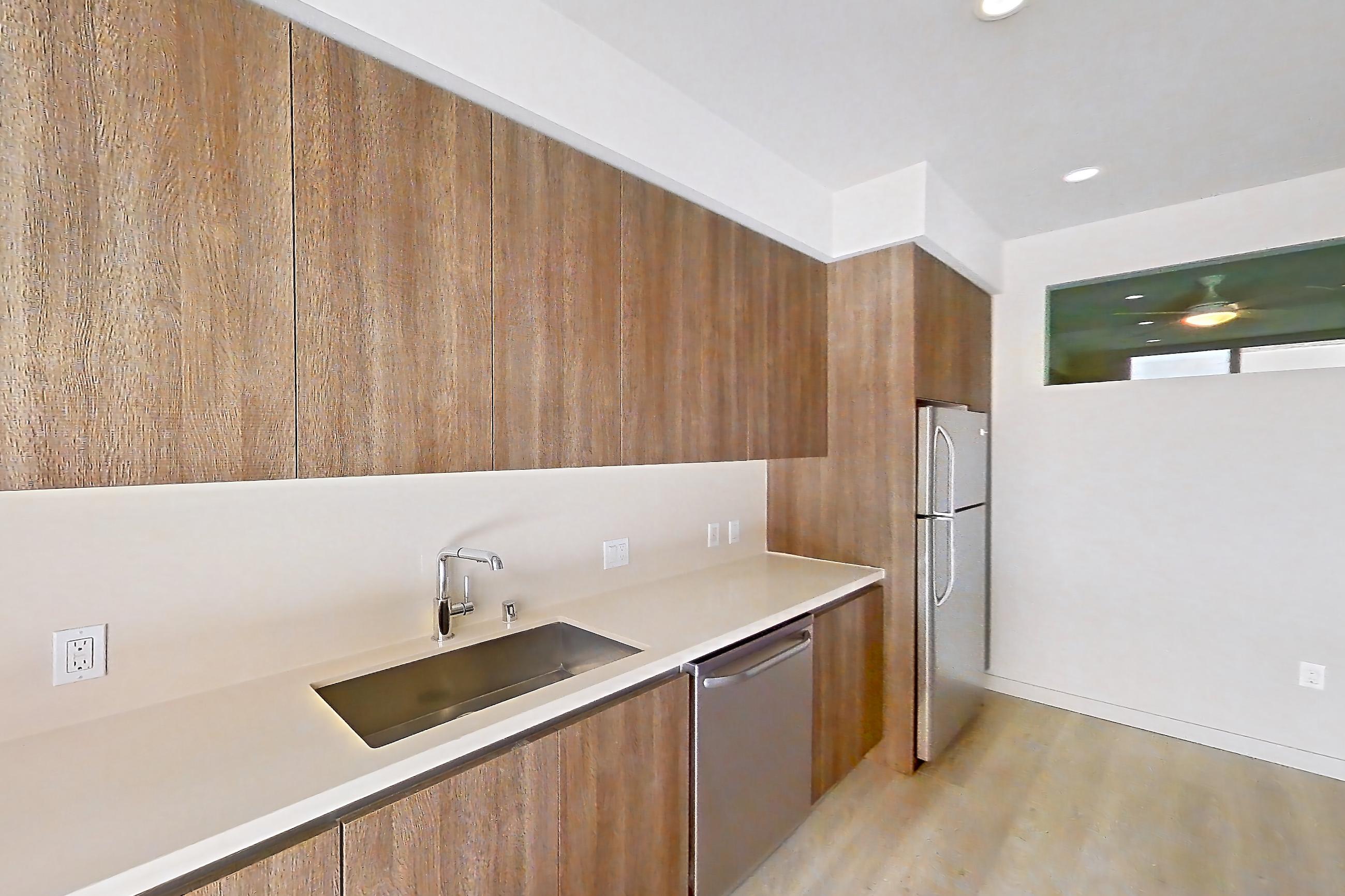 Kitchen with dishwasher, light countertops, light wood-finish flooring, refrigerator, stainless steel appliances, and white appliances, Apartment 0-5059 at Eighth and Grand
