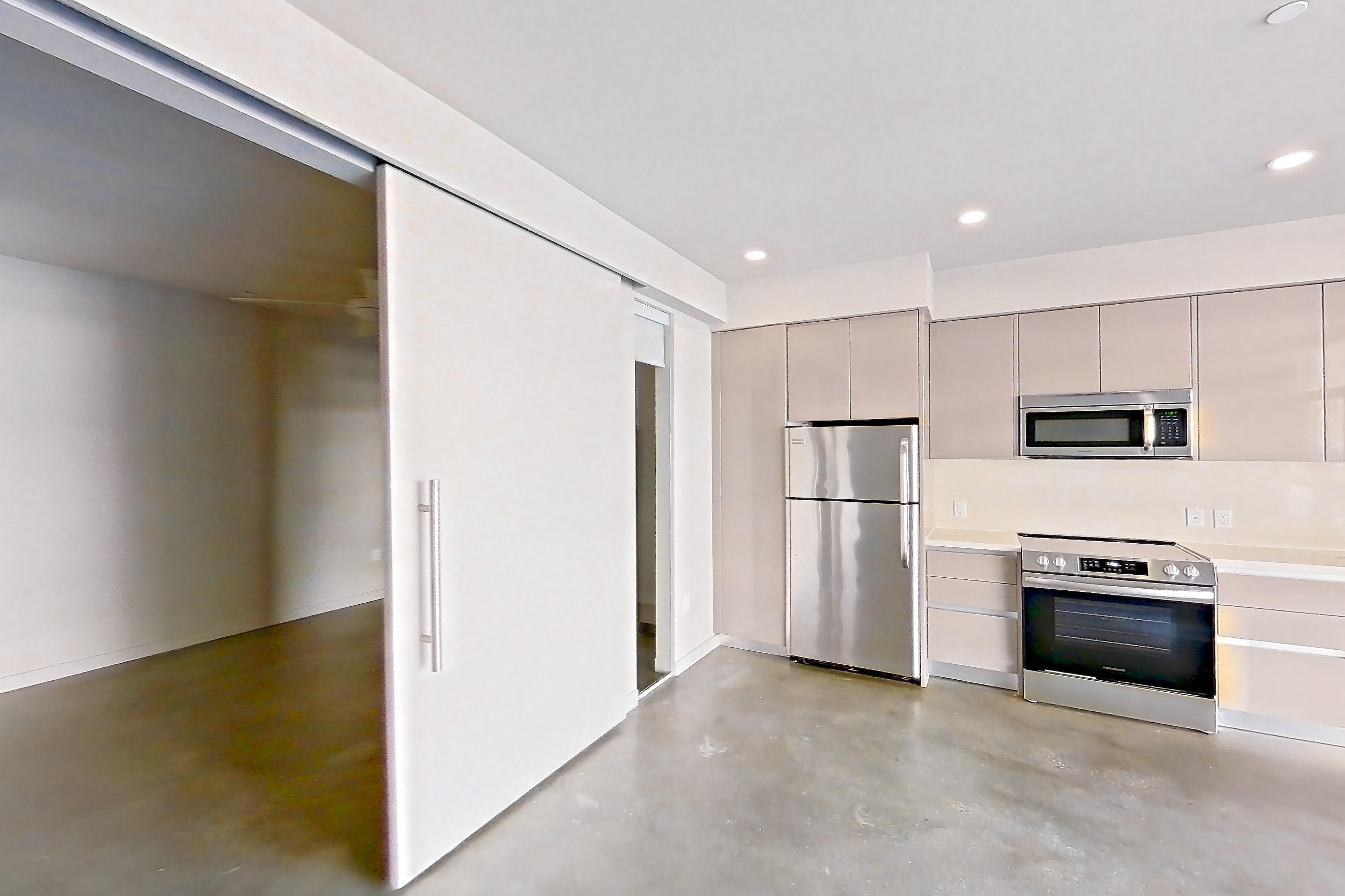 Living room with dark concrete flooring, polished concrete flooring, refrigerator, and white appliances, Apartment 0-2017 at Eighth and Grand