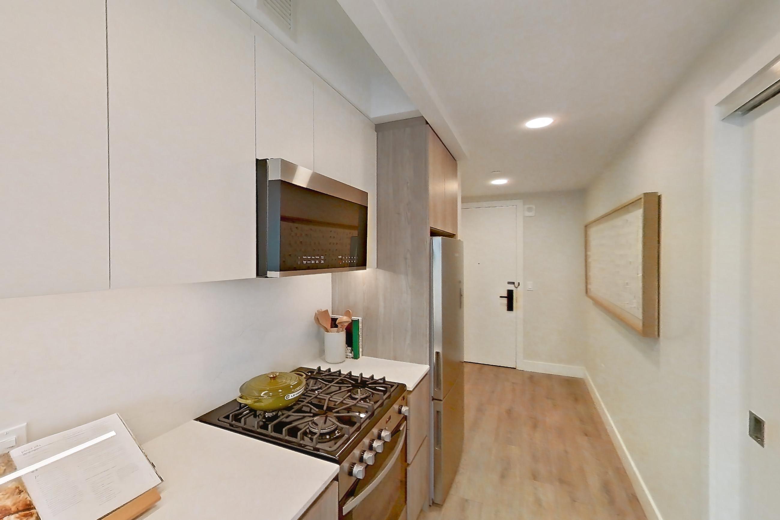 Kitchen with gas range, light wood-finish flooring, oven/range, and stainless steel appliances, Apartment 905 at Loden