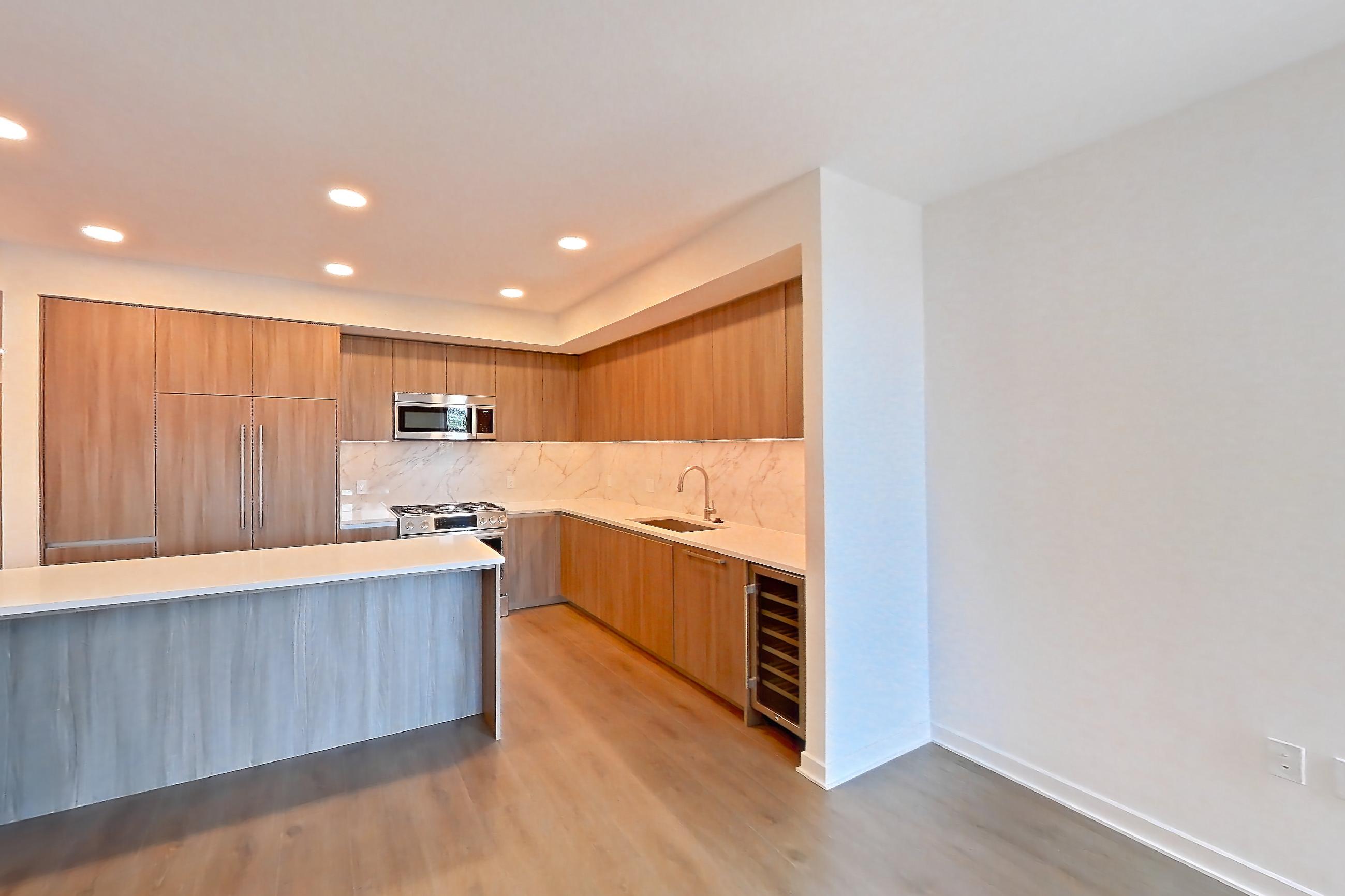 Living room with city view, light wood-finish flooring, wet bar, and wet/dry bar, Apartment 0310 at Aerie