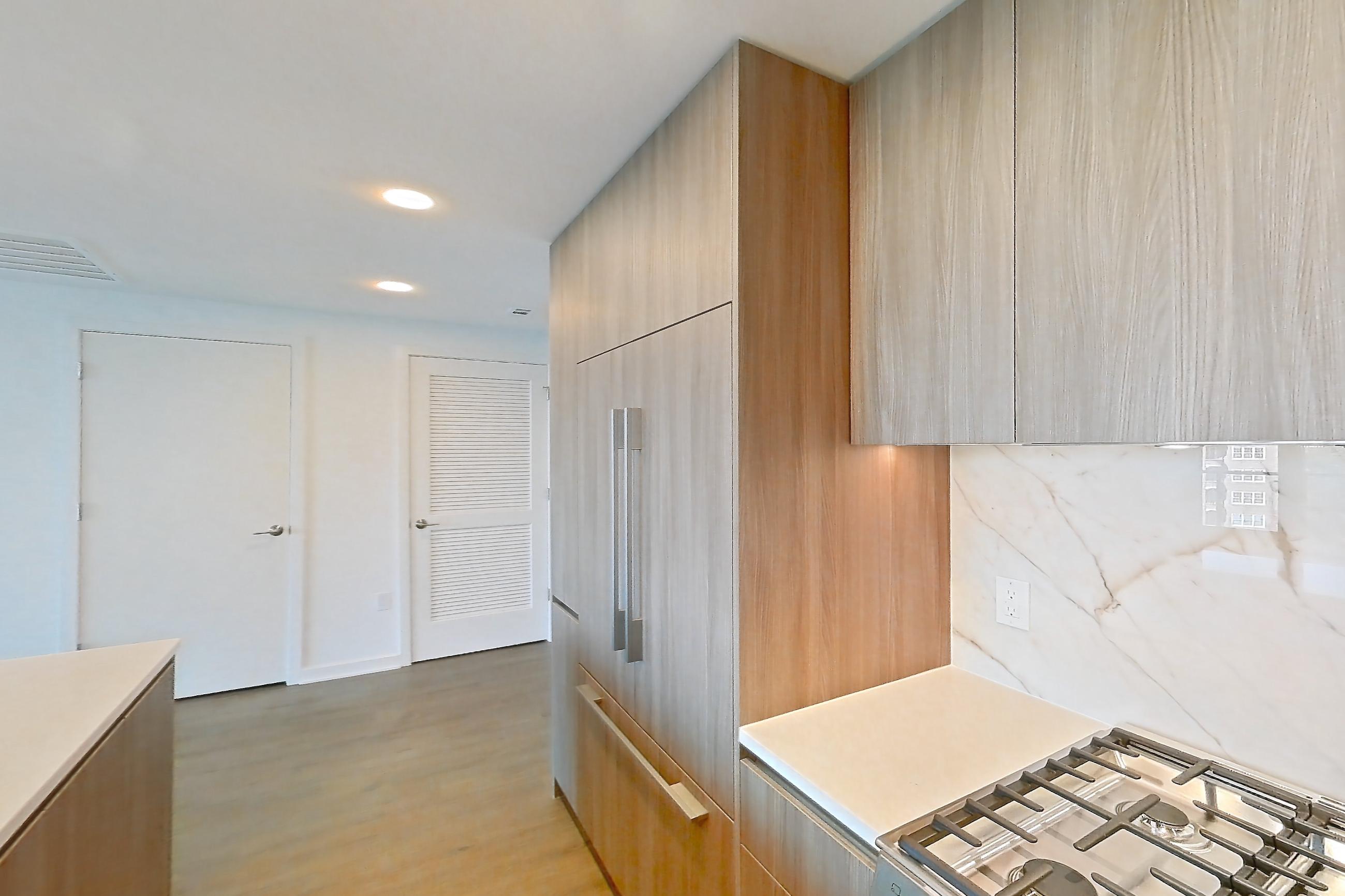 Kitchen with gas range, light stone countertops, light wood-finish flooring, oven/range, and stainless steel appliances, Apartment 0716 at Aerie
