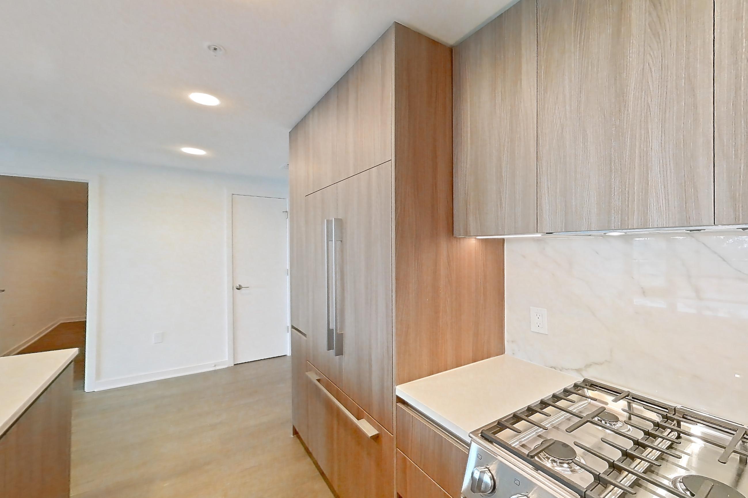 Kitchen with gas range, light stone countertops, light wood-finish flooring, oven/range, and stainless steel appliances, Apartment 0613 at Aerie