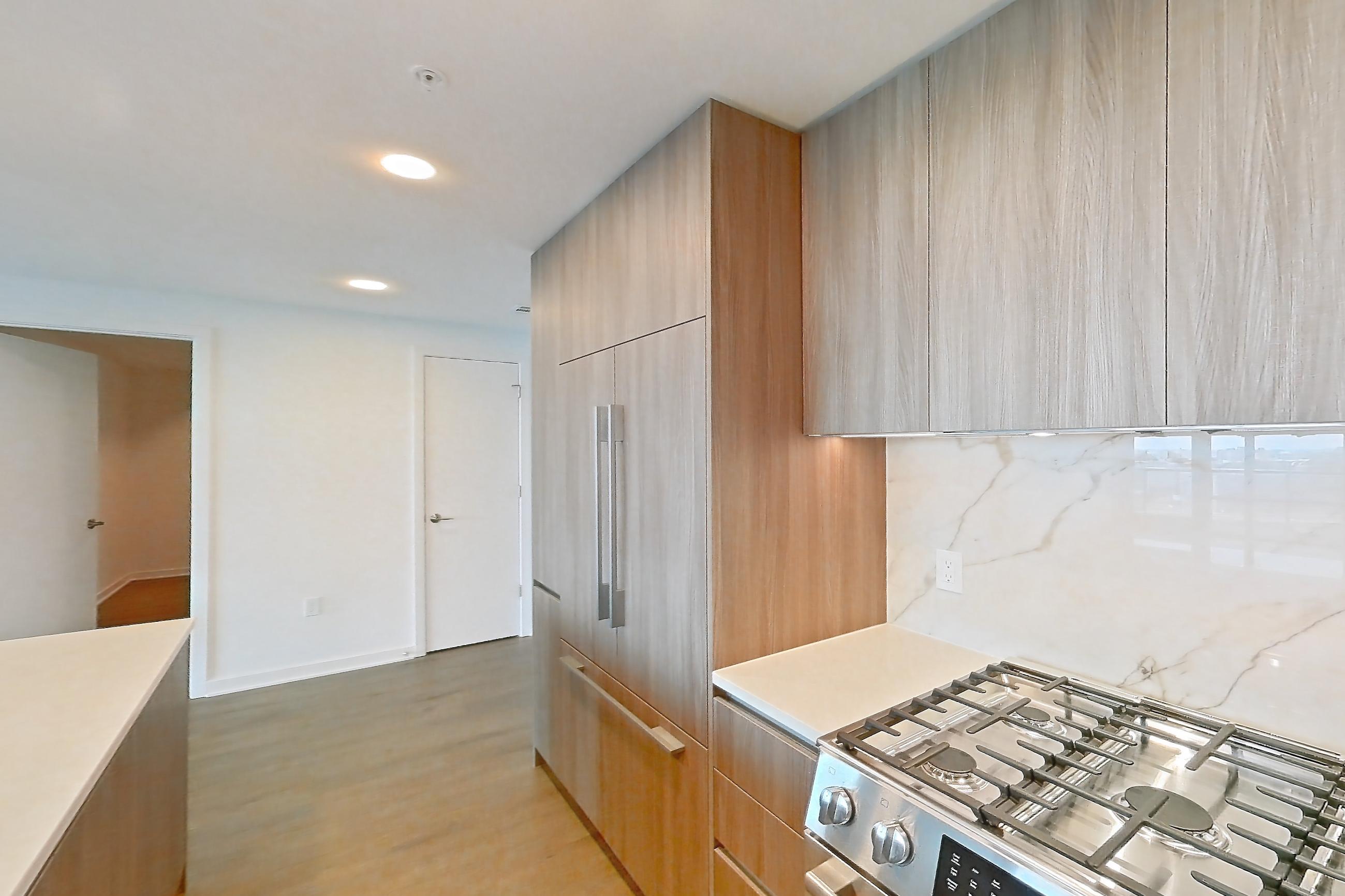 Kitchen with gas range, light stone countertops, light wood-finish flooring, oven/range, and stainless steel appliances, Apartment 0812 at Aerie