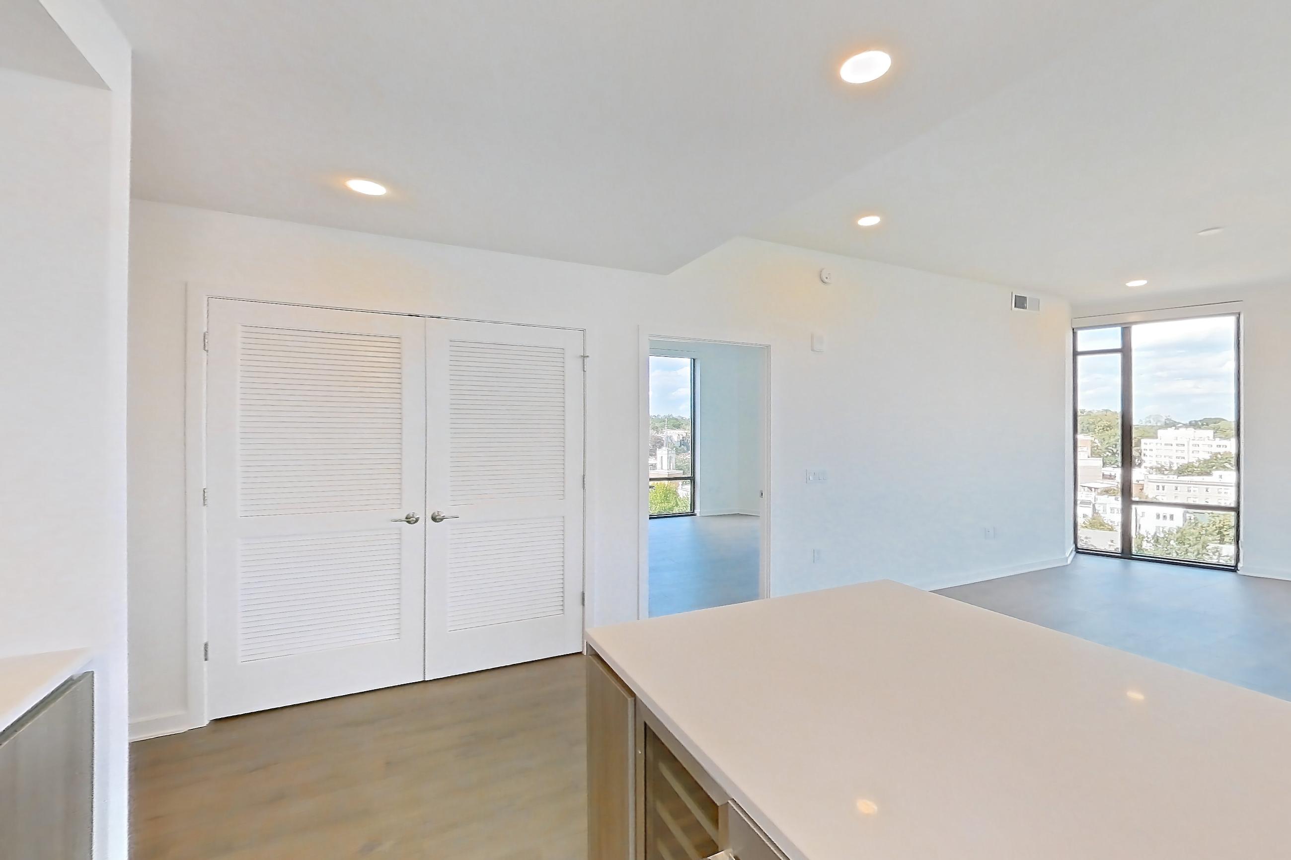 Kitchen with dark wood-finish flooring, gas range, light stone countertops, light wood-finish flooring, oven/range, and stainless steel appliances, Apartment 0921 at Aerie