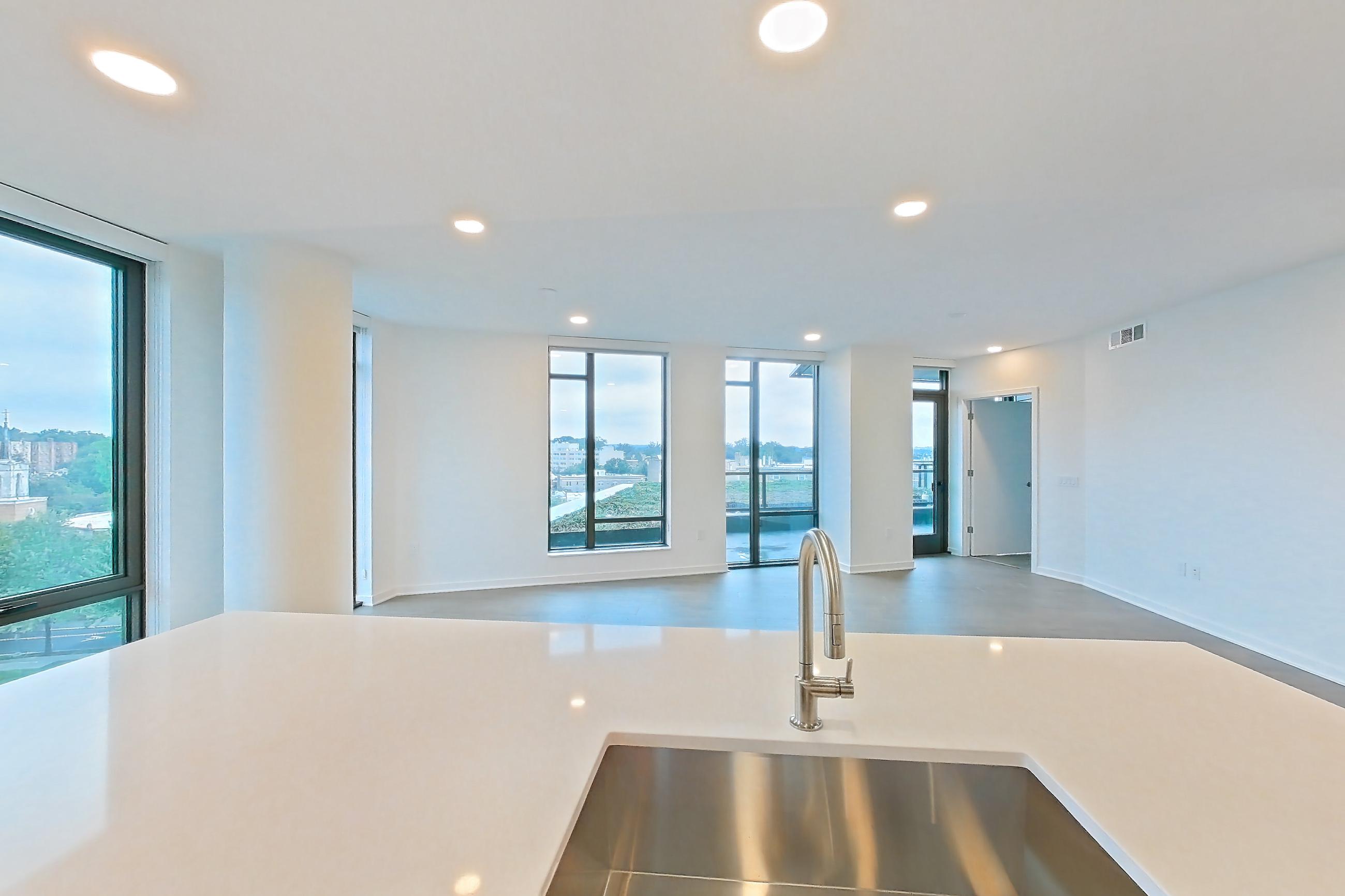 Kitchen with gas range, light stone countertops, light tile flooring, light wood-finish flooring, oven/range, and stainless steel appliances, Apartment 0822 at Aerie