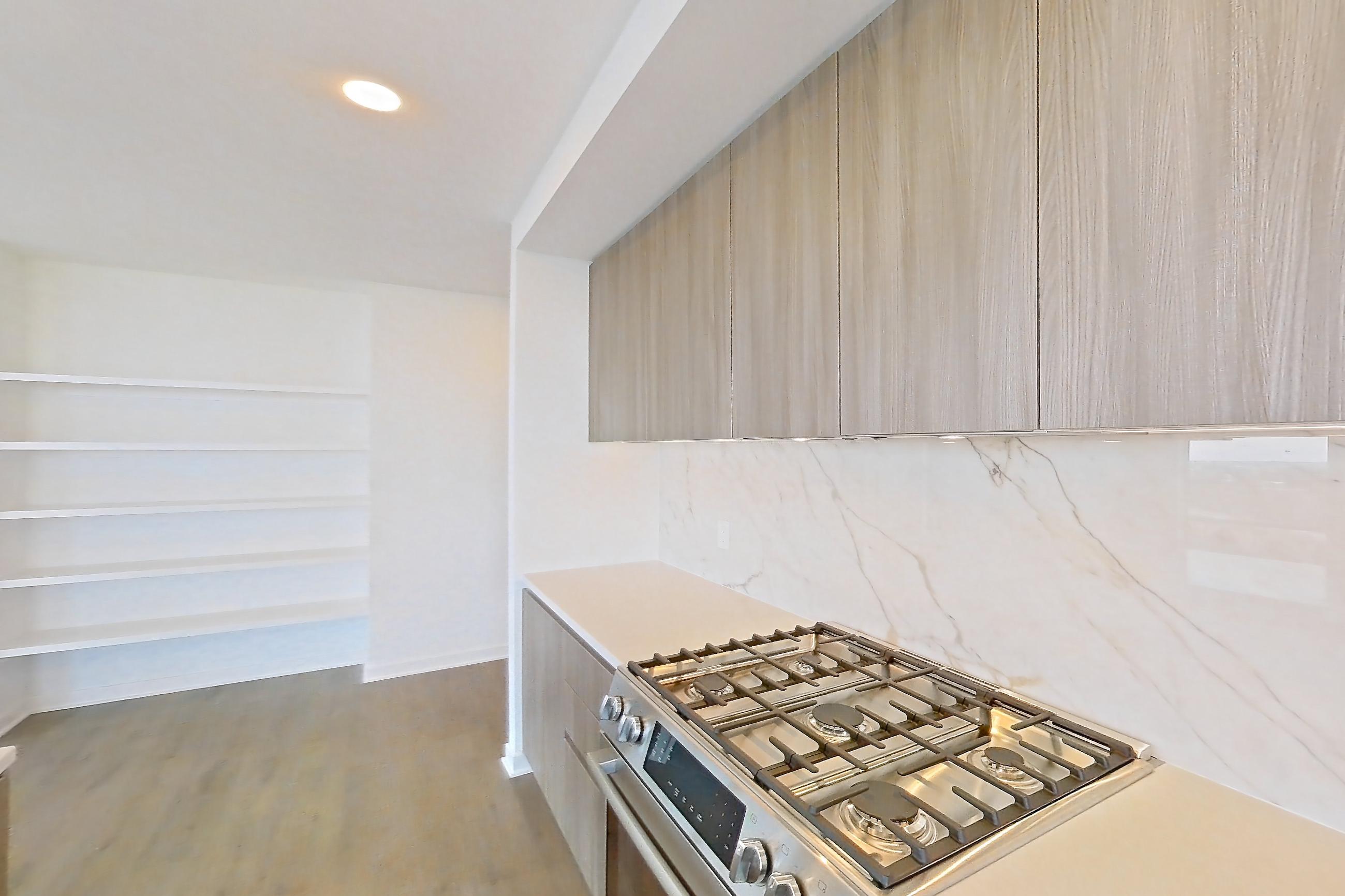 Kitchen with gas range, light stone countertops, light wood-finish flooring, oven/range, and stainless steel appliances, Apartment 0908 at Aerie