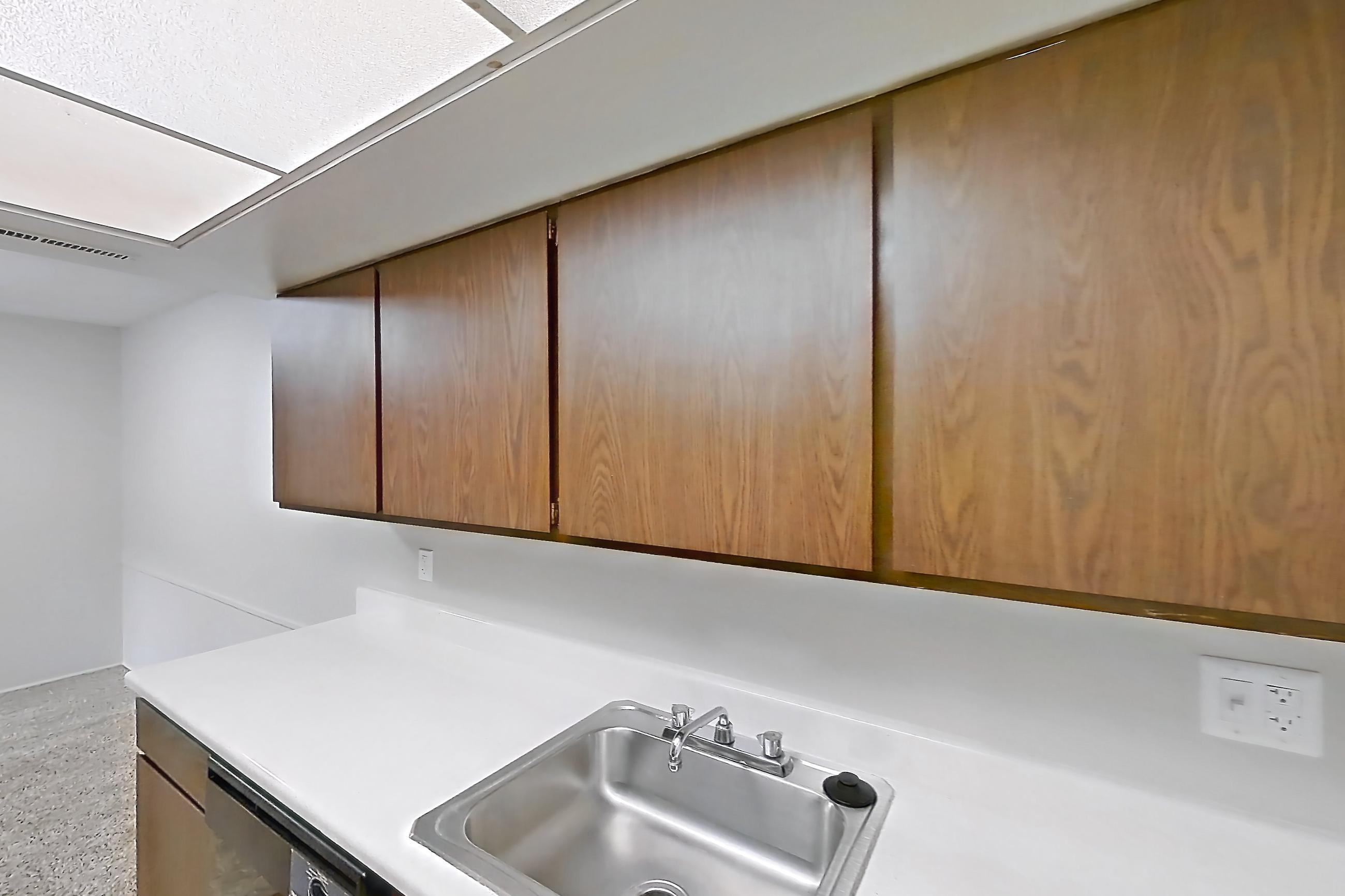 Kitchen closet with black appliances, light countertops, light wood-finish flooring, and oven/range, Apartment 2834-4NO at Canterbury Green