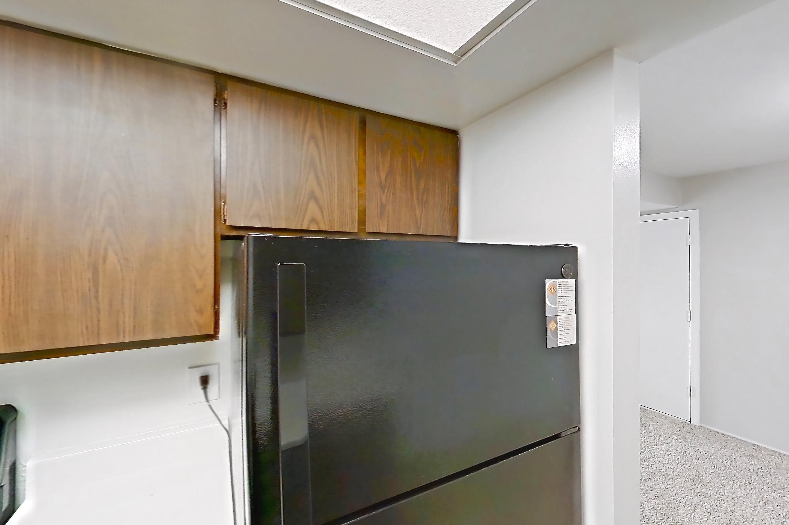 Kitchen with black appliances, dishwasher, light countertops, light wood-finish flooring, oven/range, and refrigerator, Apartment 2834-4NO at Canterbury Green