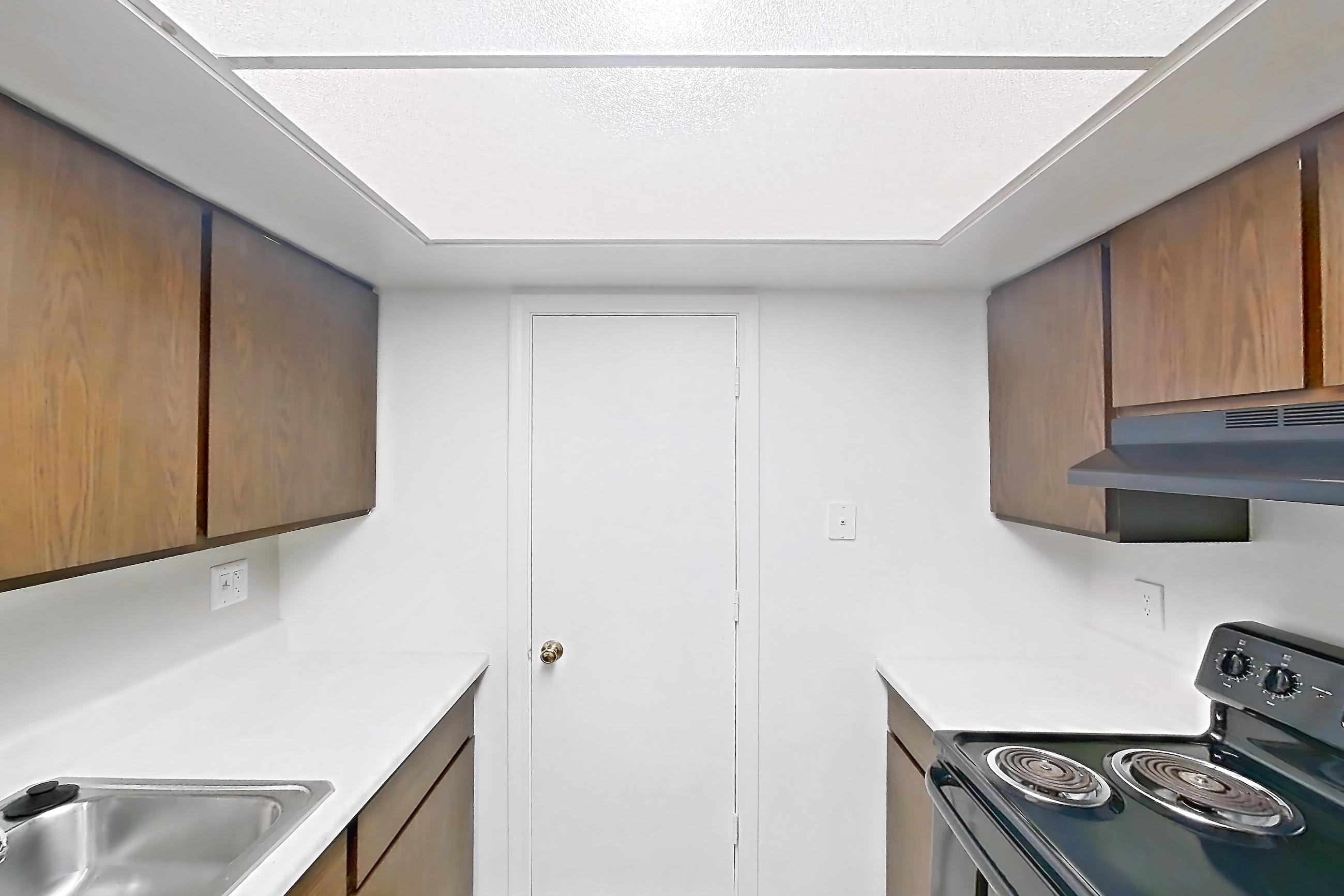 Kitchen with black appliances, dishwasher, light countertops, light wood-finish flooring, oven/range, and refrigerator, Apartment 2834-4NO at Canterbury Green