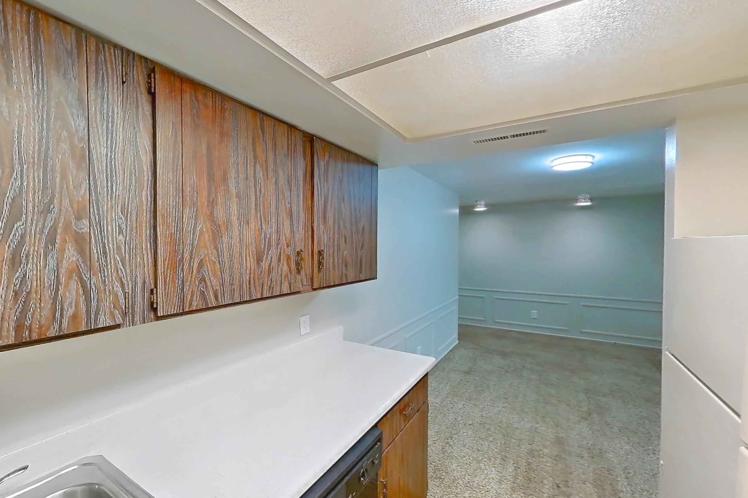 Kitchen with black appliances, dishwasher, electric range, light carpet, light countertops, light wood-finish flooring, oven/range, refrigerator, and white appliances, Apartment 2603-7AB at Canterbury Green