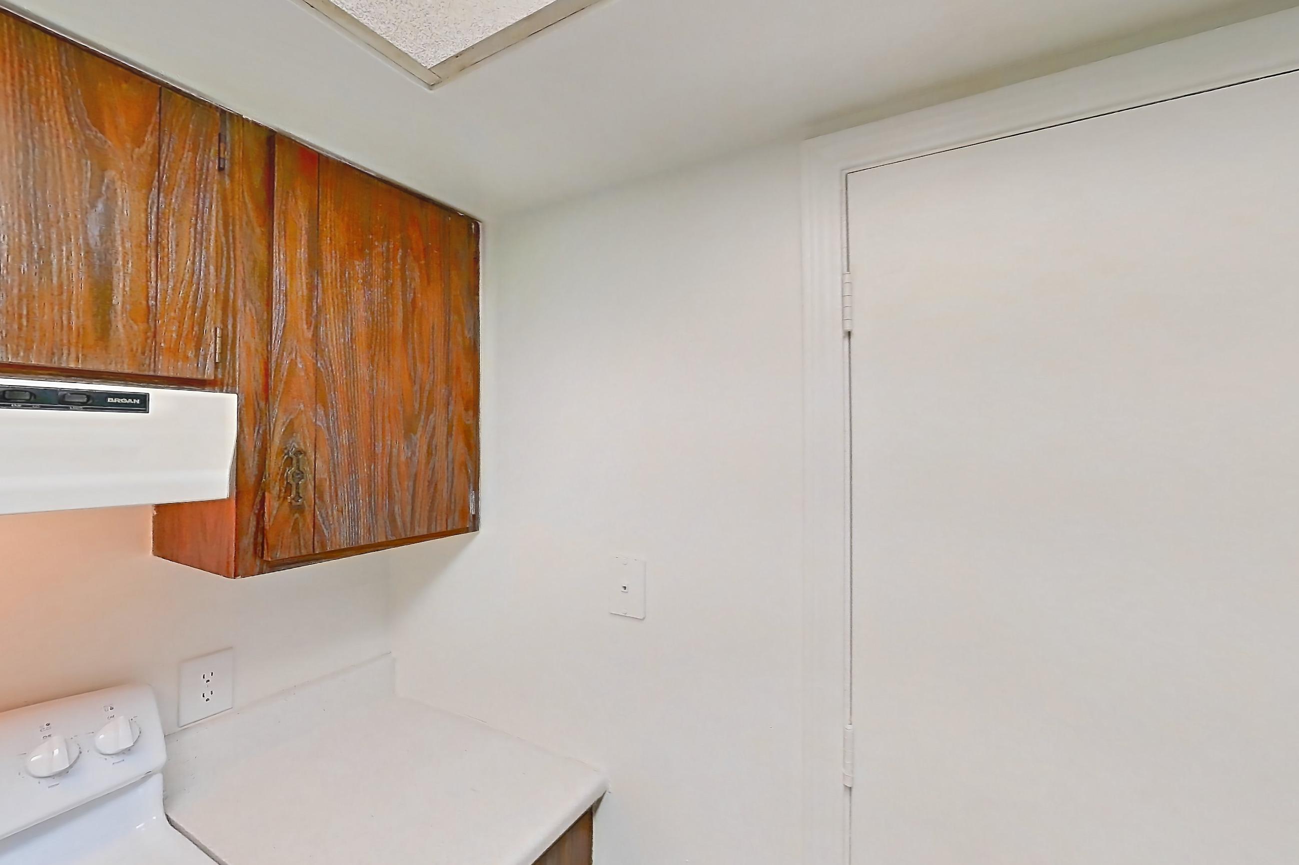 Kitchen with black appliances, dishwasher, electric range, light carpet, light countertops, light wood-finish flooring, oven/range, refrigerator, and white appliances, Apartment 2603-7AB at Canterbury Green