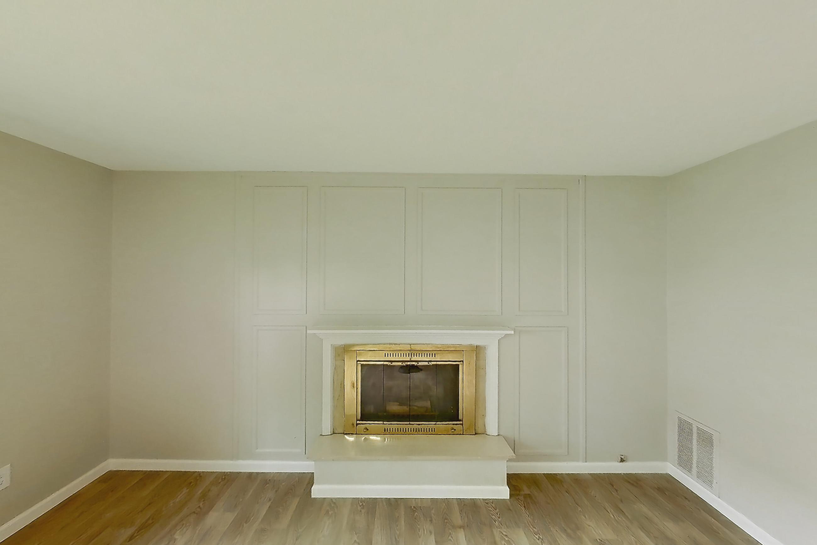 Living room with fireplace and light wood-finish flooring, Apartment 2924CA at Canterbury Green