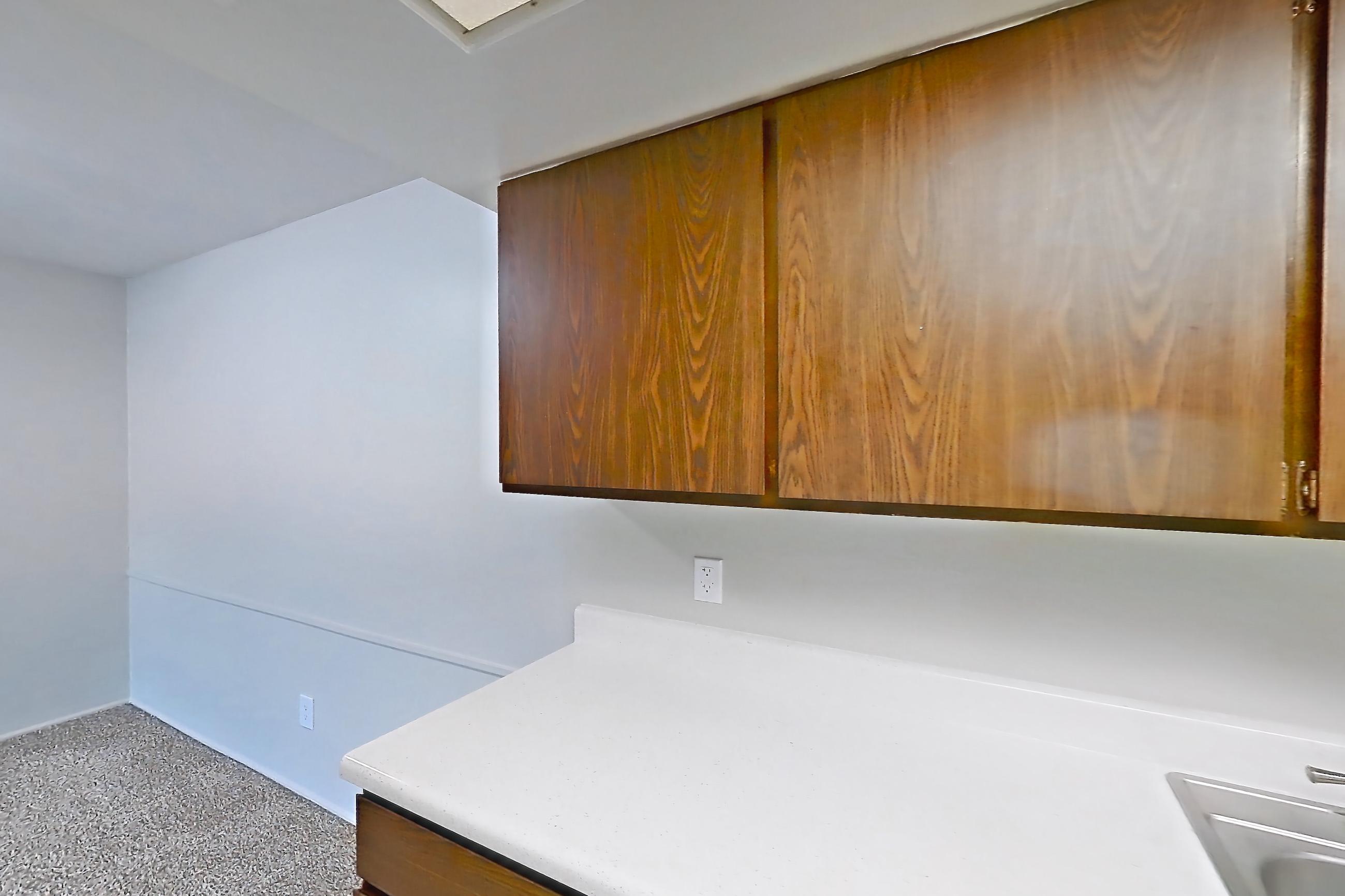 Kitchen with black appliances, dishwasher, light countertops, light stone countertops, light wood-finish flooring, oven/range, refrigerator, and white appliances, Apartment 2803-8NO at Canterbury Green