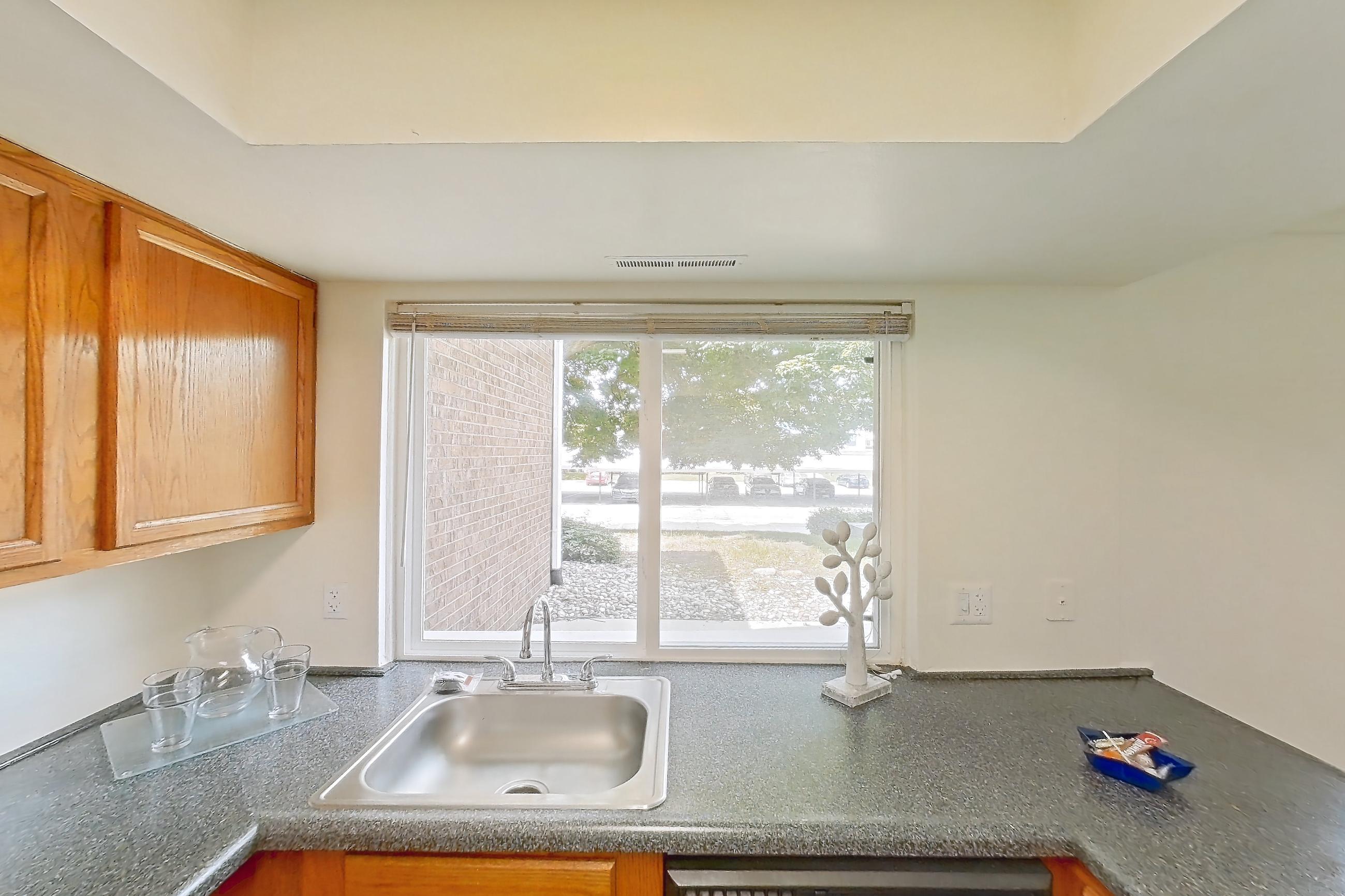 Kitchen with black appliances, dark countertops, dishwasher, electric range, light wood-finish flooring, oven/range, and white appliances, Apartment 3014CA at Canterbury Green