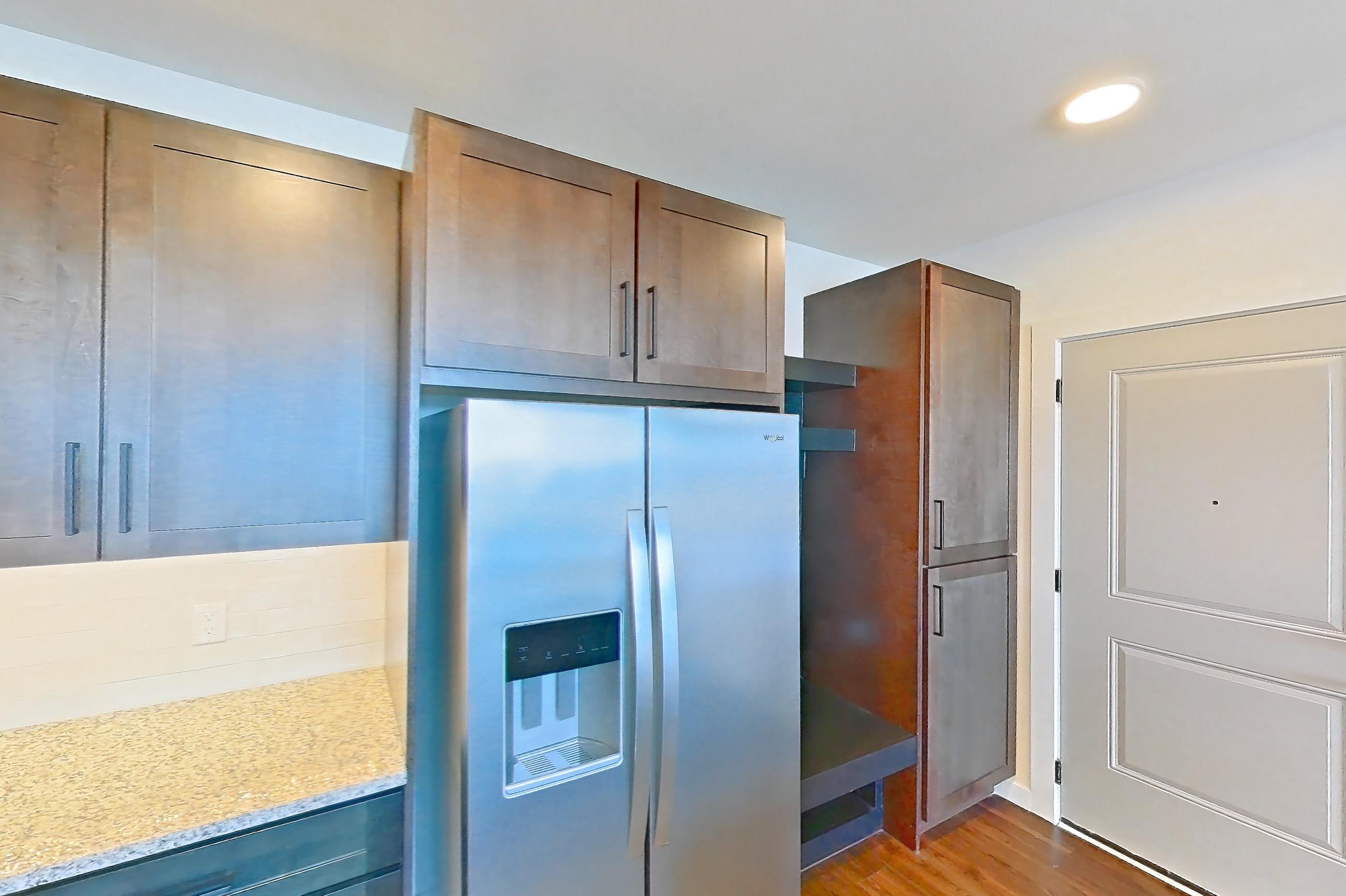 Kitchen with dark wood-finish flooring, dishwasher, electric range, light stone countertops, oven/range, refrigerator, stainless steel appliances, water & ice dispenser, and white appliances, Apartment 3-409 at Cortland Peterson