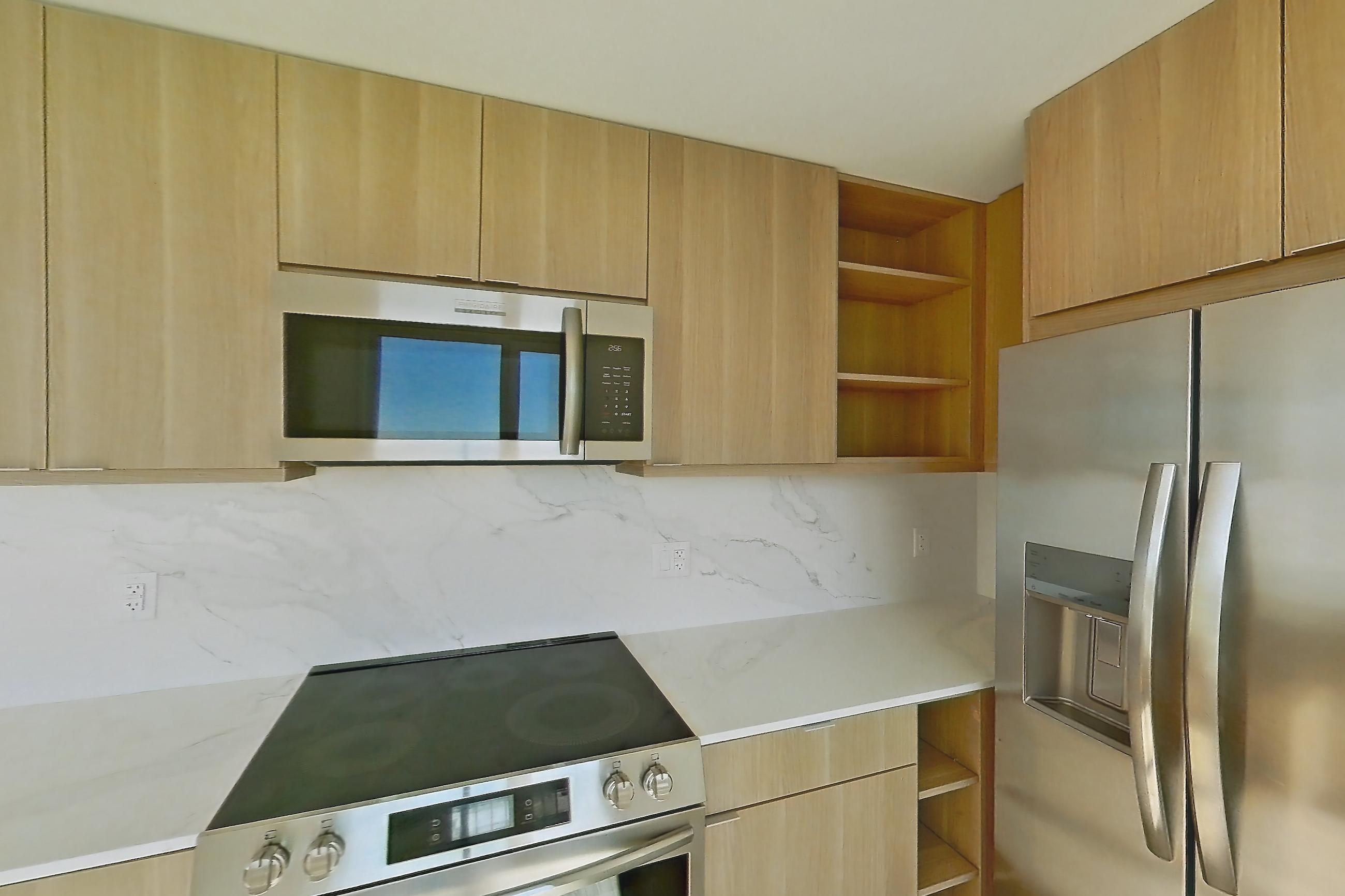 Kitchen with electric range, light stone countertops, light wood-finish flooring, oven/range, and stainless steel appliances, Apartment PH11 at Residences at Mazza