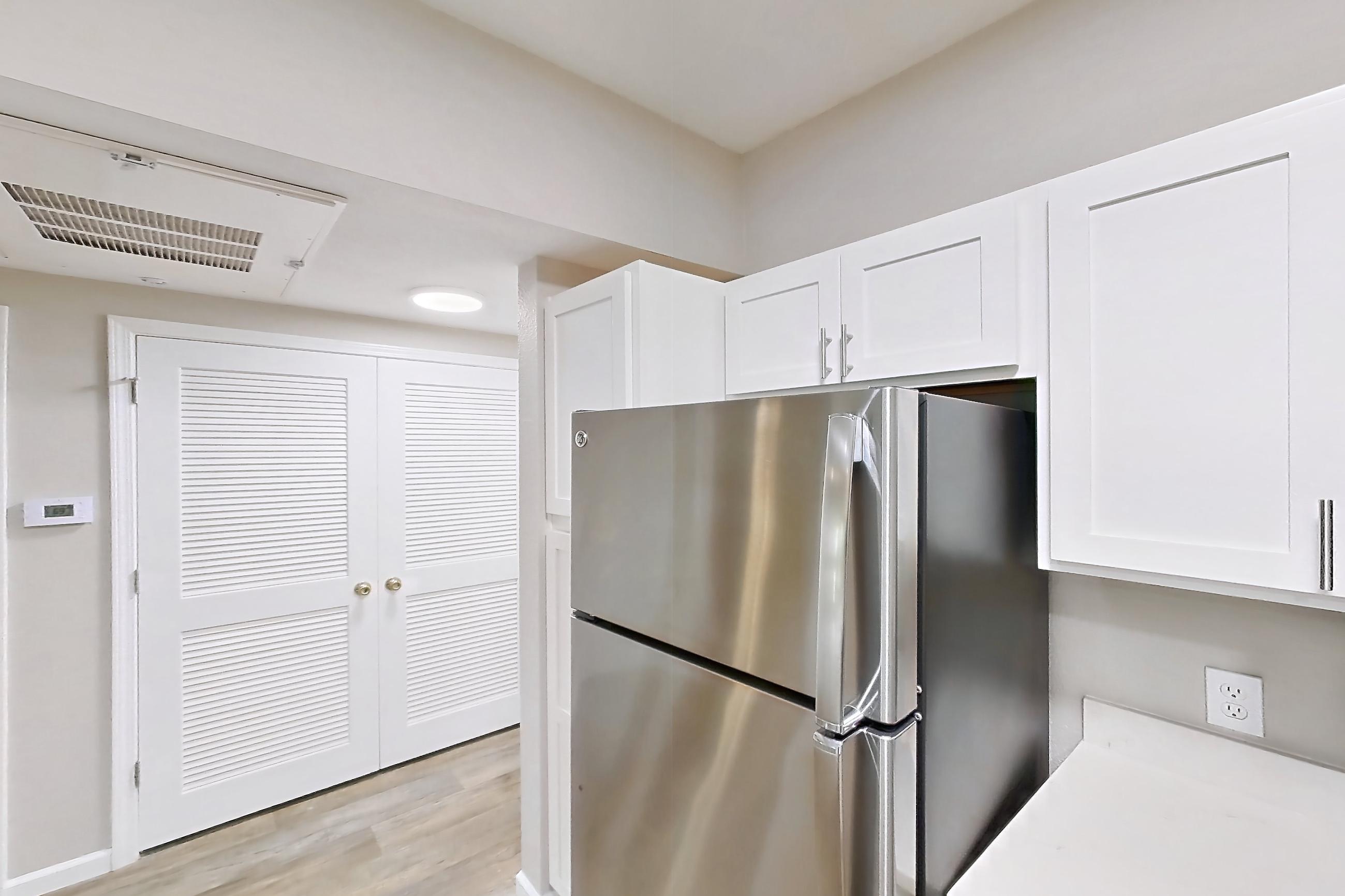 Kitchen with dishwasher, electric range, fireplace, light stone countertops, light wood-finish flooring, microwave, oven/range, and stainless steel appliances, Apartment Bradford 1 at Bradford Pointe