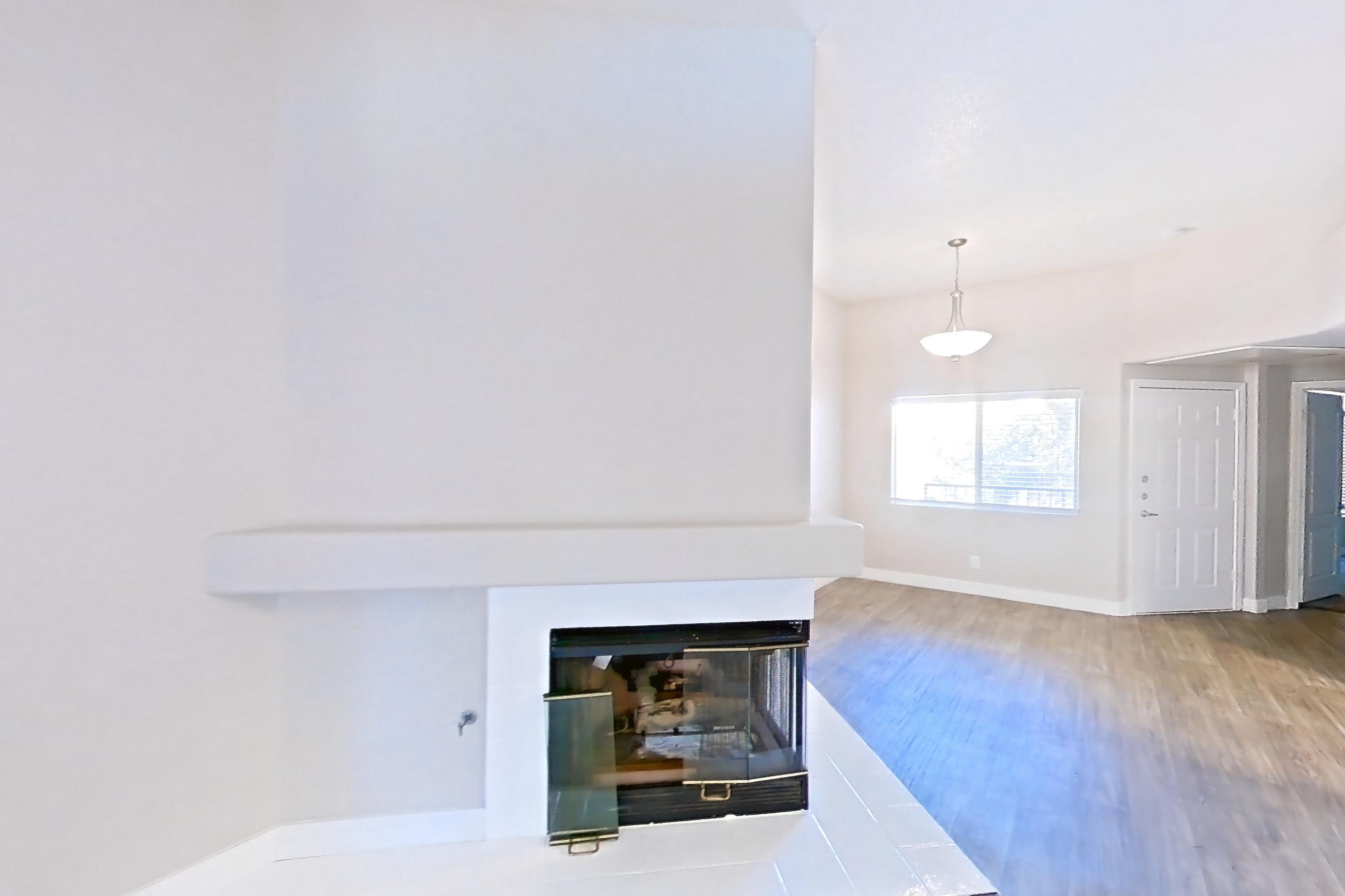 Living room with dark wood-finish flooring and fireplace, Apartment 2030 at Monaco Park