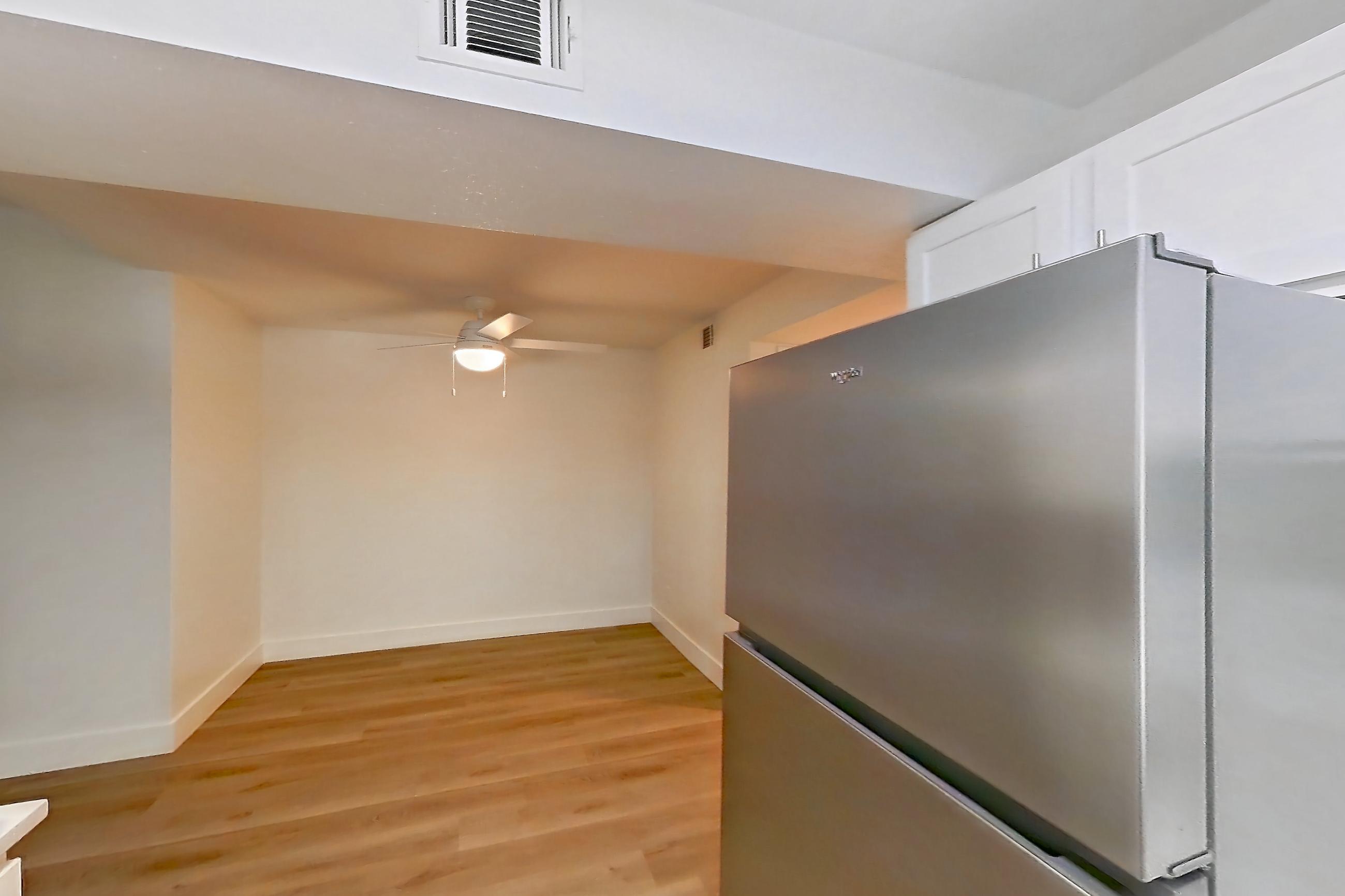 Kitchen with dishwasher, electric range, light countertops, light wood-finish flooring, microwave, oven/range, refrigerator, and stainless steel appliances, Apartment 01-2004 at Xander 3900
