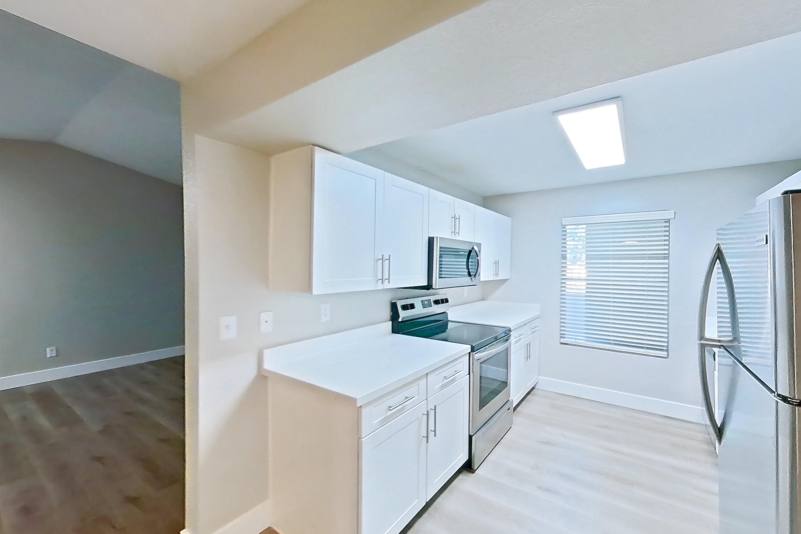 Dining room with electric range, light countertops, light wood-finish flooring, oven/range, and stainless steel appliances, Apartment 14-2107 at Xander 3900