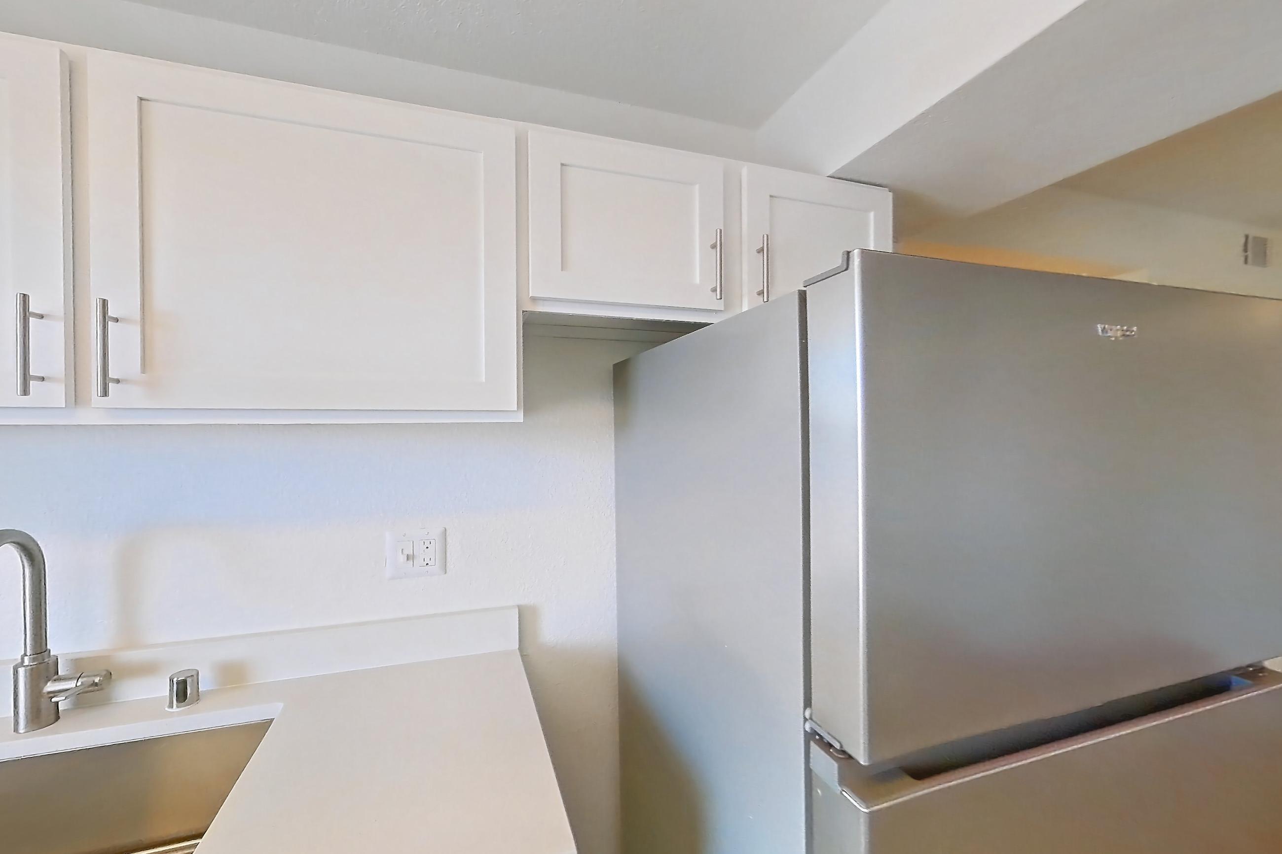 Kitchen with dishwasher, electric range, light countertops, light stone countertops, light wood-finish flooring, microwave, oven/range, refrigerator, and stainless steel appliances, Apartment 34-2089 at Xander 3900