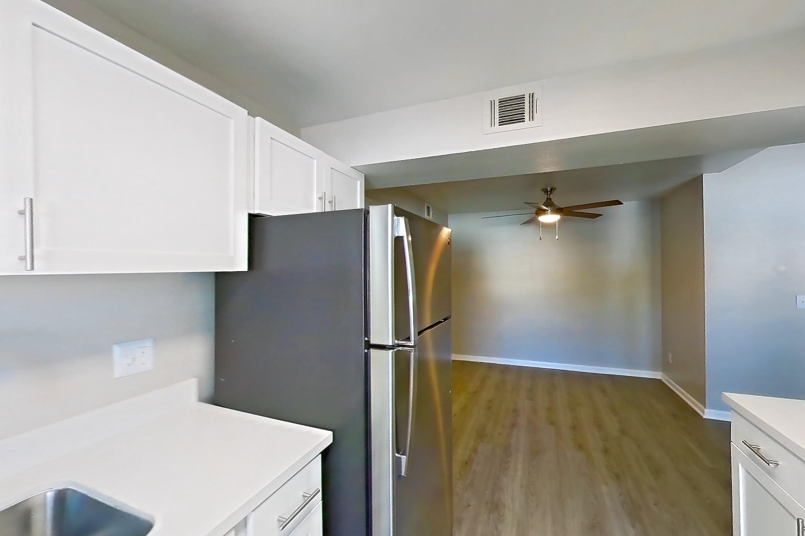 Kitchen with electric range, light countertops, light wood-finish flooring, microwave, oven/range, refrigerator, and stainless steel appliances, Apartment 19-2039 at Xander 3900