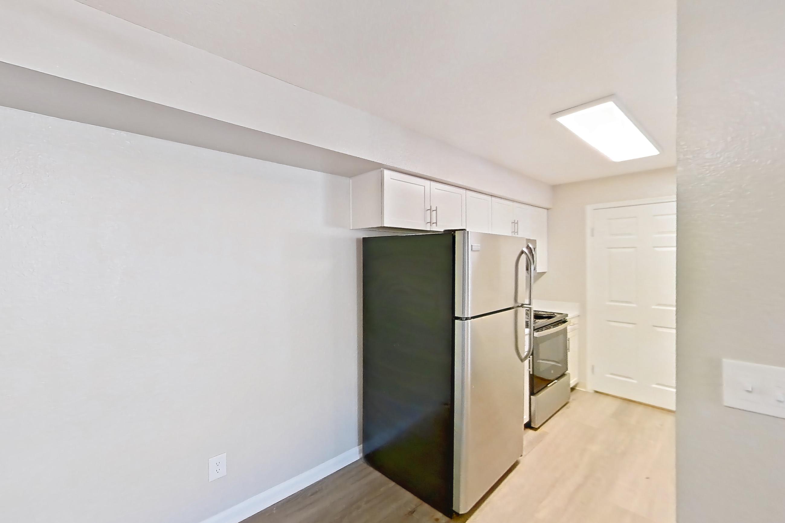 Dining room with dark wood-finish flooring, electric range, light countertops, oven/range, refrigerator, and stainless steel appliances, Apartment 30-2084 at Xander 3900